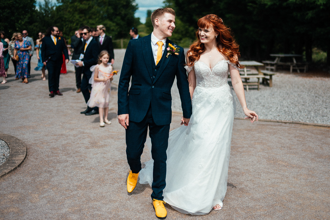 Newlywed couple with a groom in yellow shoes, tie and buttonhole UK documentary wedding photographer Simon Dewey