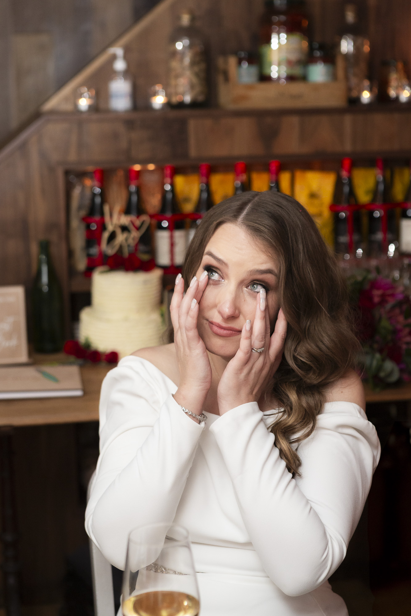 Beautiful photograph of a tearful bride as she listens to speeches on her wedding day. By Essex wedding photographer Ross Willsher