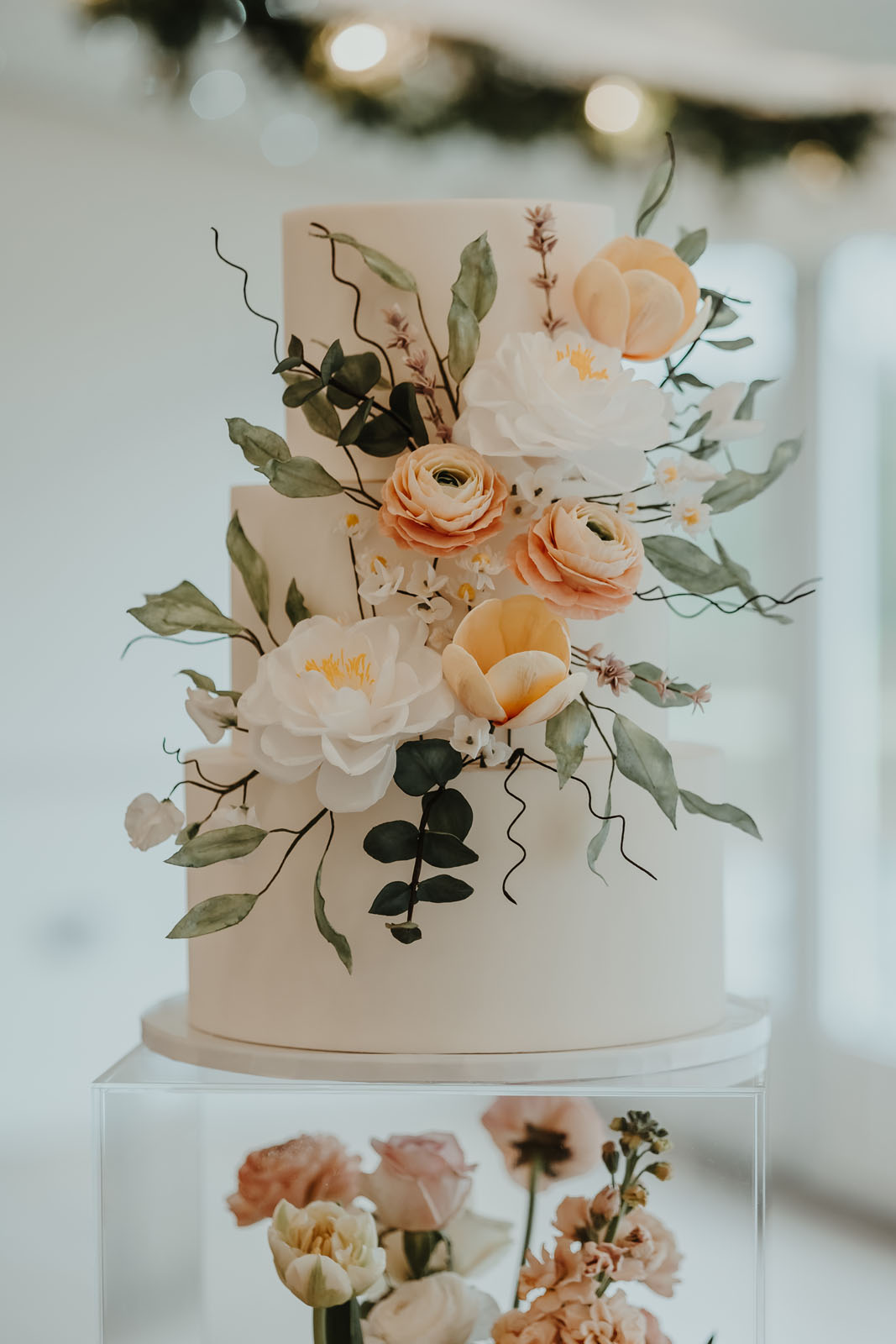 3 tier wedding cake with pastel peach and coral sugar paste flowers