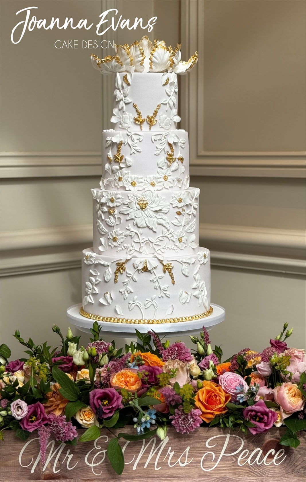 intricate tiered wedding cake with embossed detail and gold highlights