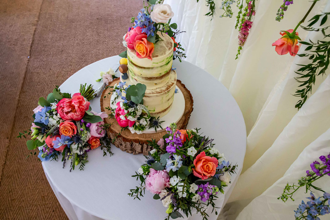 wedding cake photographed from above, on a table full of colourful flowers