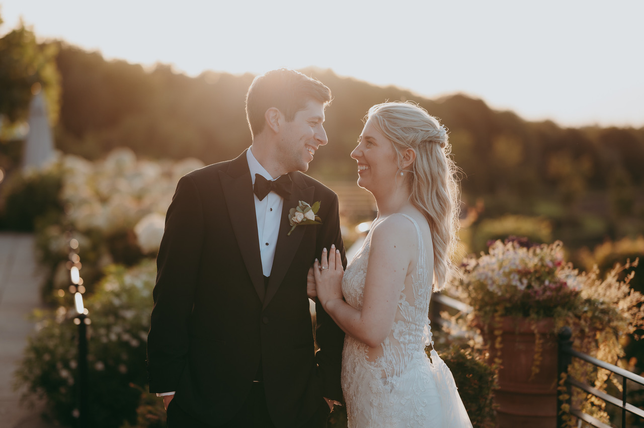 Golden hour portrait of a groom and bride with the gardens of their wedding venue in the background - by Damien Vickers Photography in Cambridge