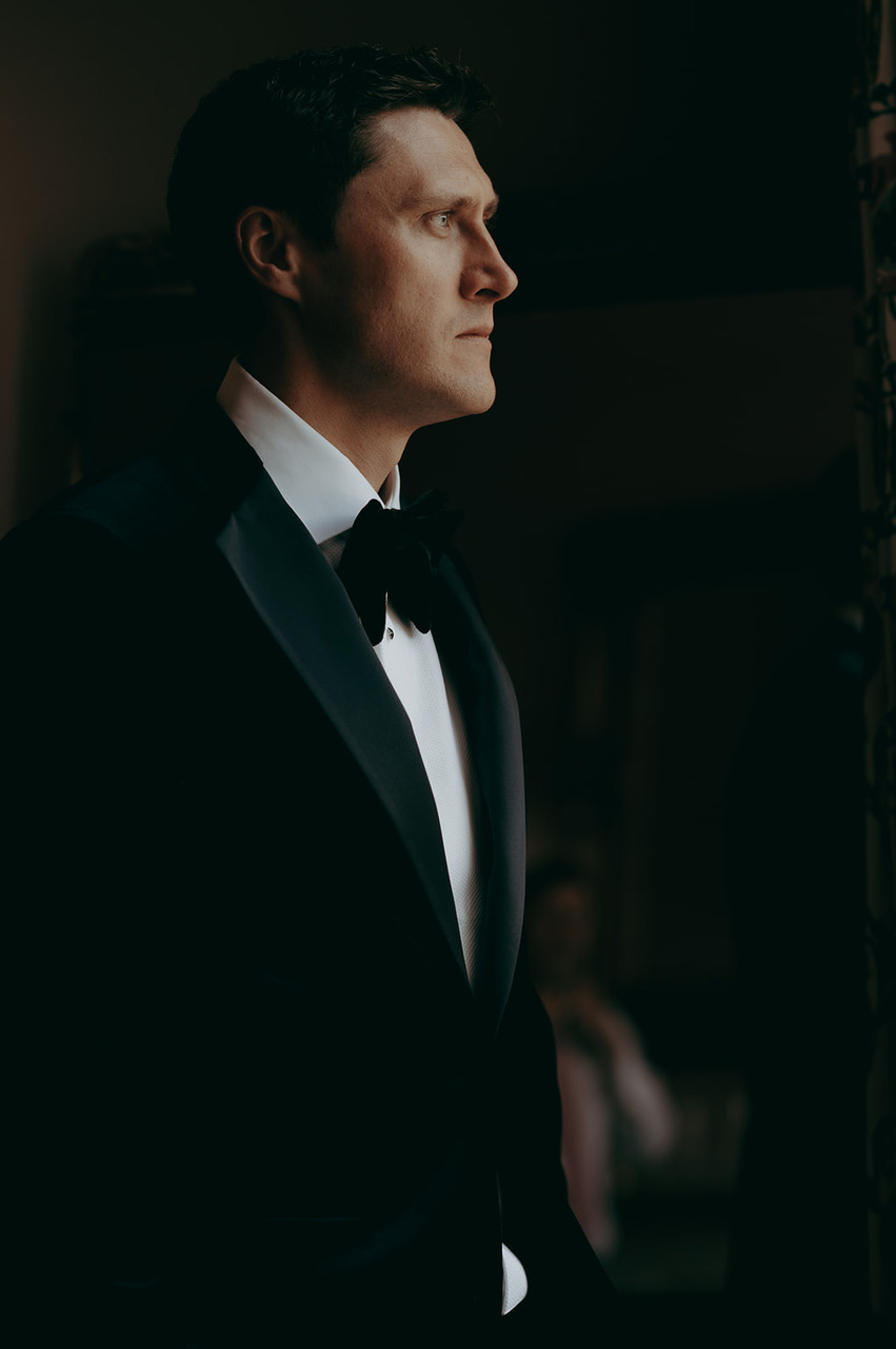 Elegant portrait of a man in black tie looking towards natural light - by Damien Vickers Photography