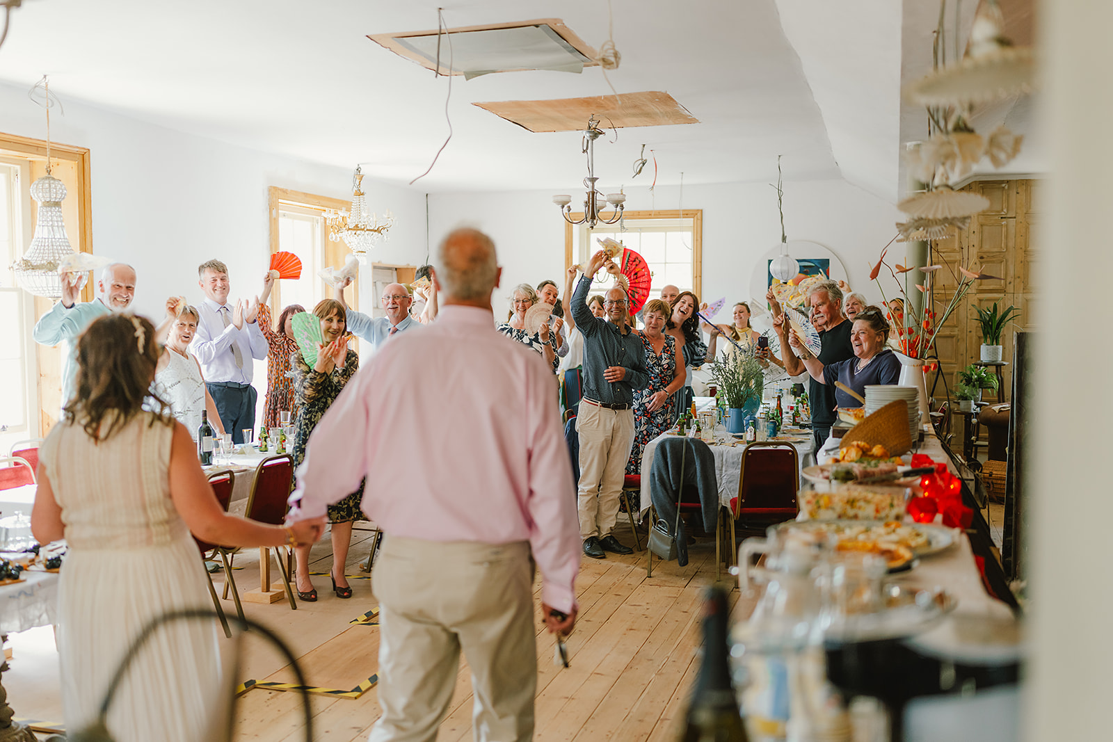 Groom and bride walking into their wedding reception to a crowd of cheering guests | Andy Davison Photography