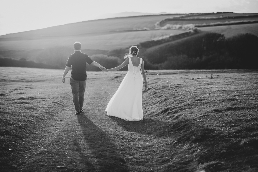 Nikita and Sam walking the clifftops at The Cow Shed Weddings in Cornwall by Evolve
