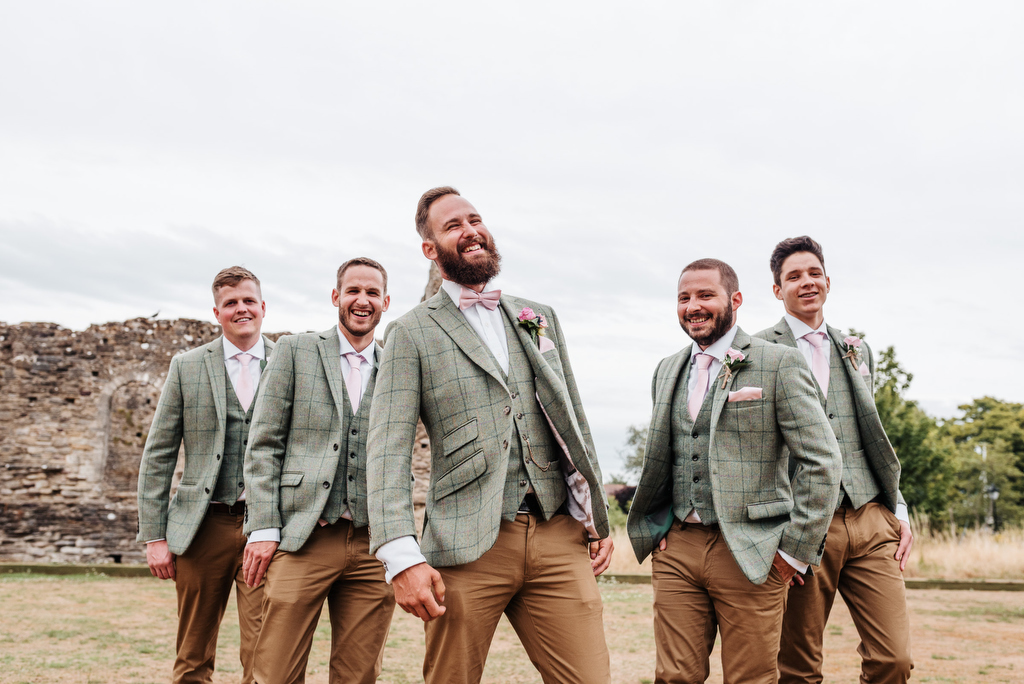 Laughing Groomsmen in suits by Libra Photographic