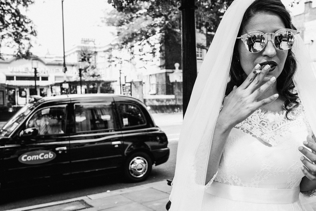 A relaxed and candid wedding in Islington. The bride and groom wear sunglasses, they're laughing with their friends and the images are authentic and unposed. Photographer credit York Place Studios