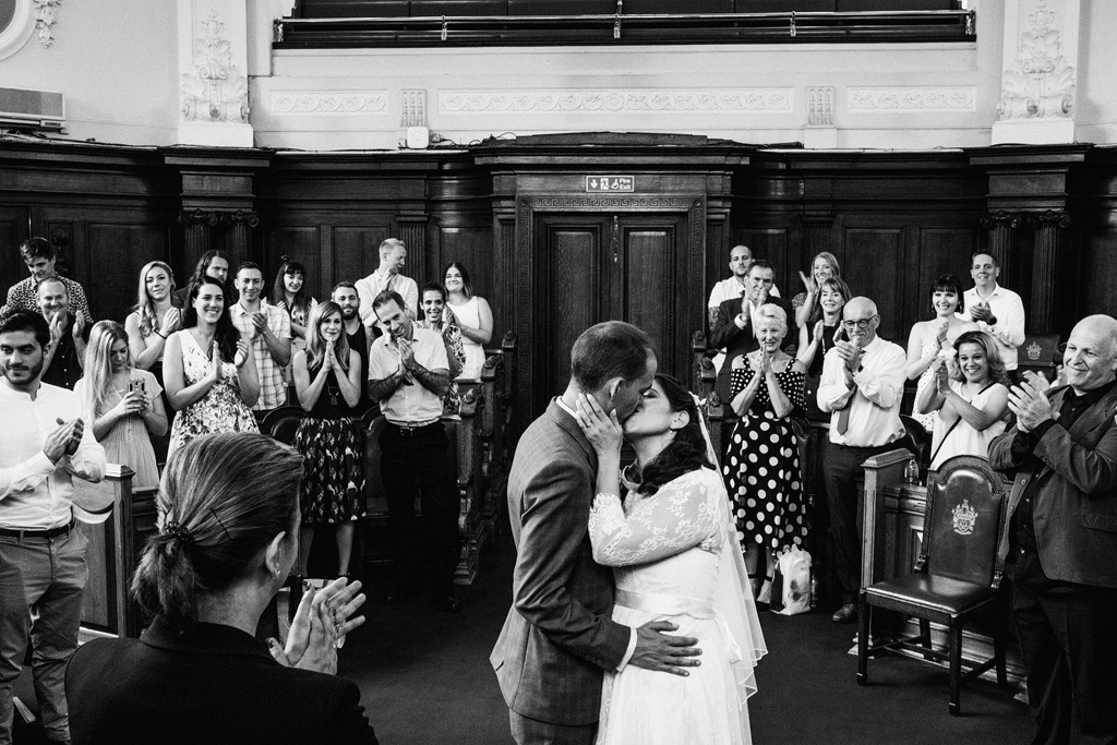 A relaxed and candid wedding in Islington. The bride and groom wear sunglasses, they're laughing with their friends and the images are authentic and unposed. Photographer credit York Place Studios