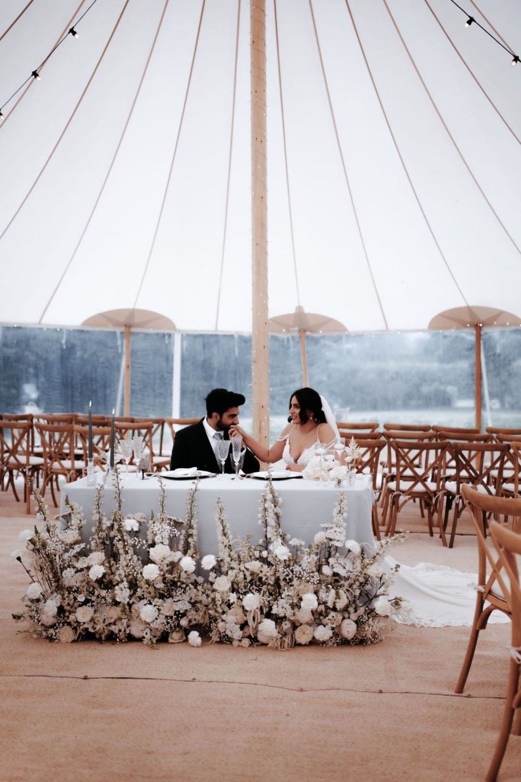 Styled wedding photoshoot with Wonderful Events on English Wedding. A bride and groom wearing black tie and white dress with all white flowers and grey tableware with smoky glass
