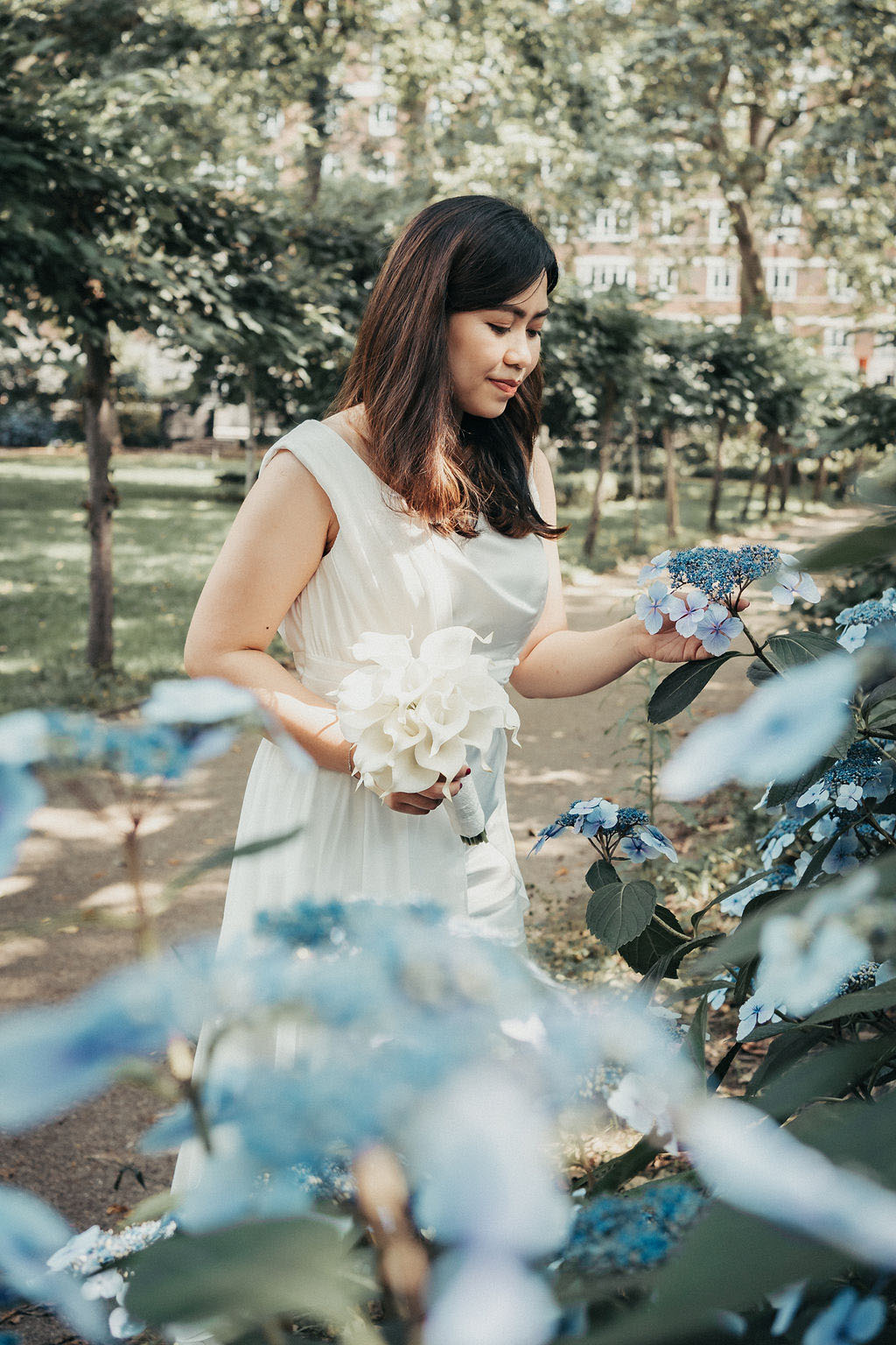 London rooftop micro wedding, Roanne wears a knee length white dress with asymmetrical skirt, Rey wears a blue suit