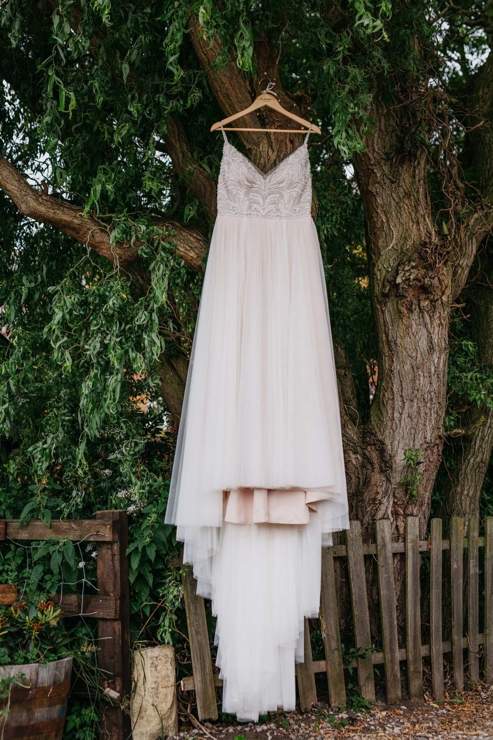 Yorkshire wedding photography of Alicia and Phil. She wears a white boho style dress and he's in a blue ckech suit. She has a full flower crown in delicate pinks, and they look happy. Image by John Hope Photography