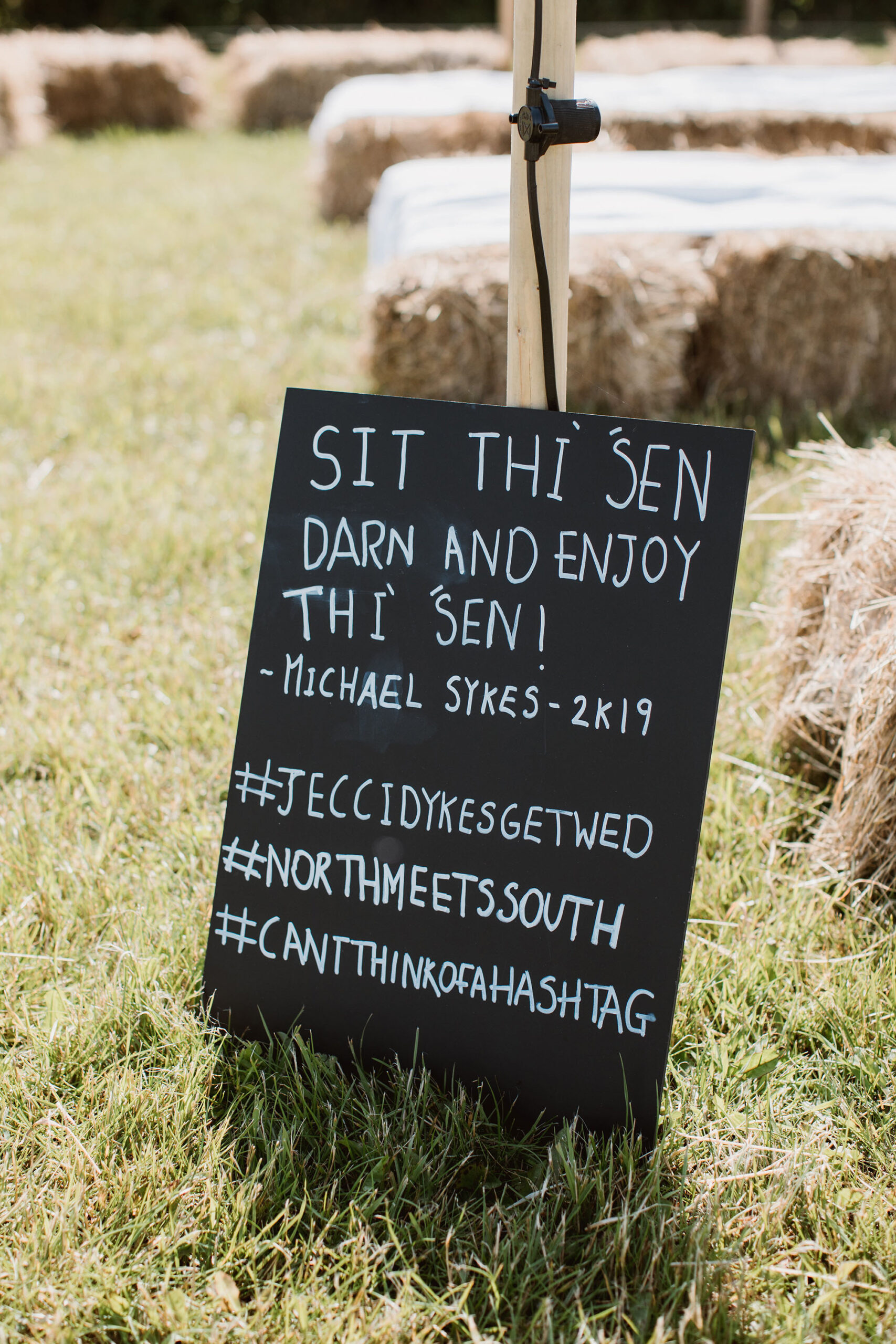 Wedding sign in a Yorkshire dialect - Sit thi sen darn and enjoy thi sen - white ink on chalkboard. Wedding image by Luke Hayden Photography