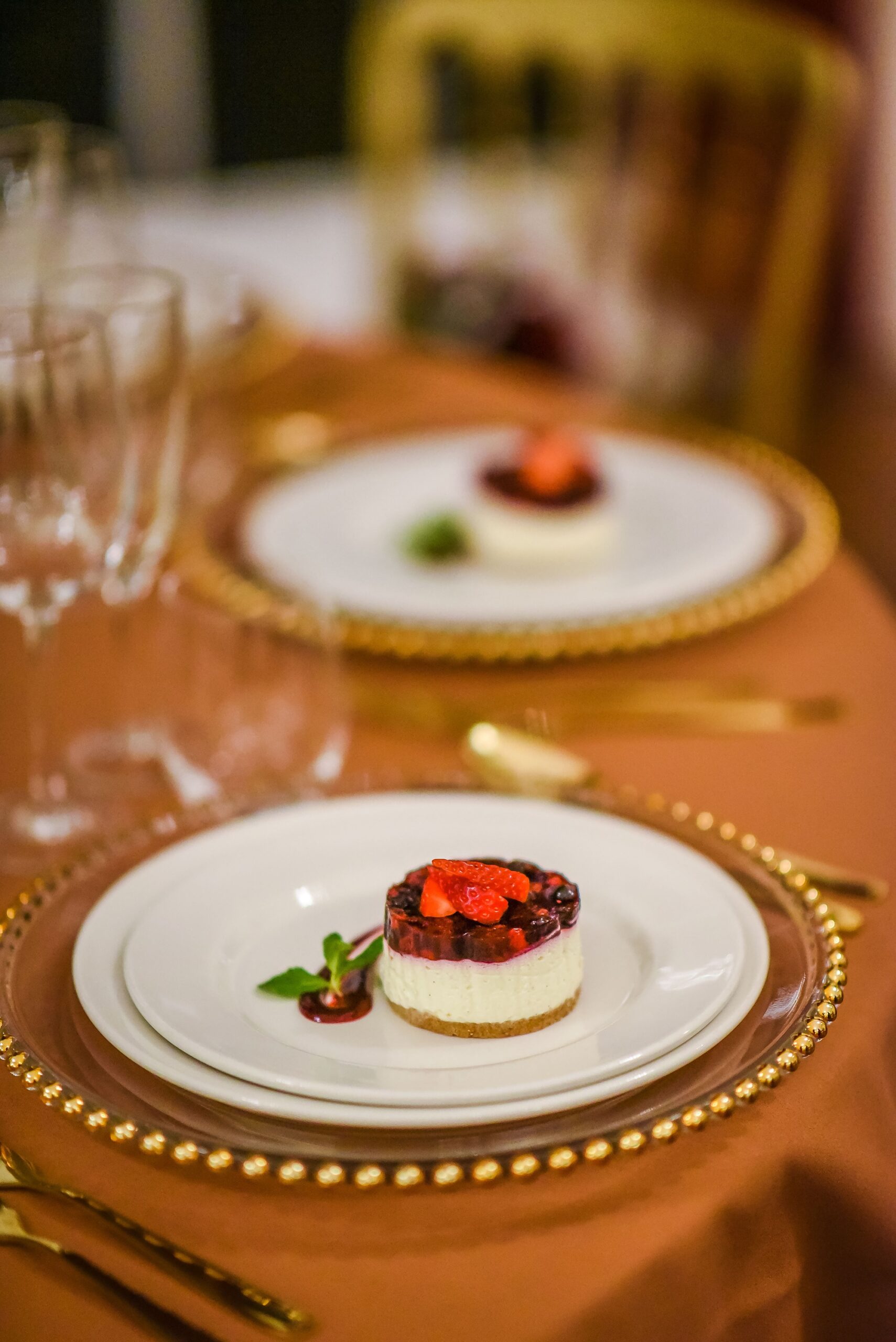 Delicate fruit cheesecakes set out on white plates on a wedding table