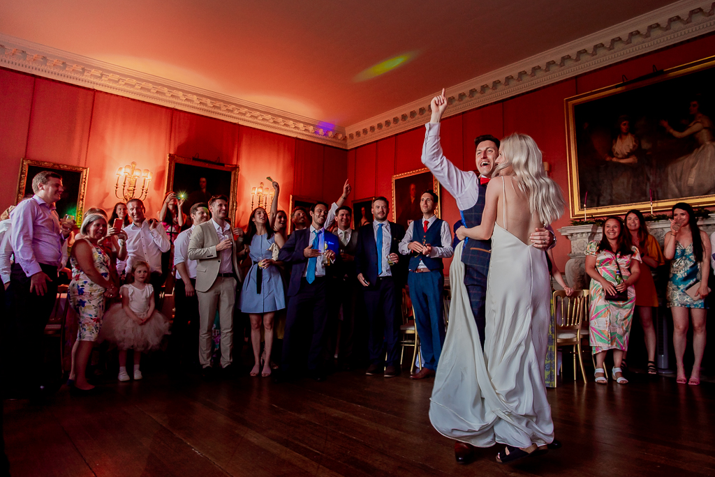 Tommy and Sarah's elegant modern Holdenby House wedding. She wears a minimal strappy dress and he's in a blue check suit. Photographer credit Damien Vickers Photography