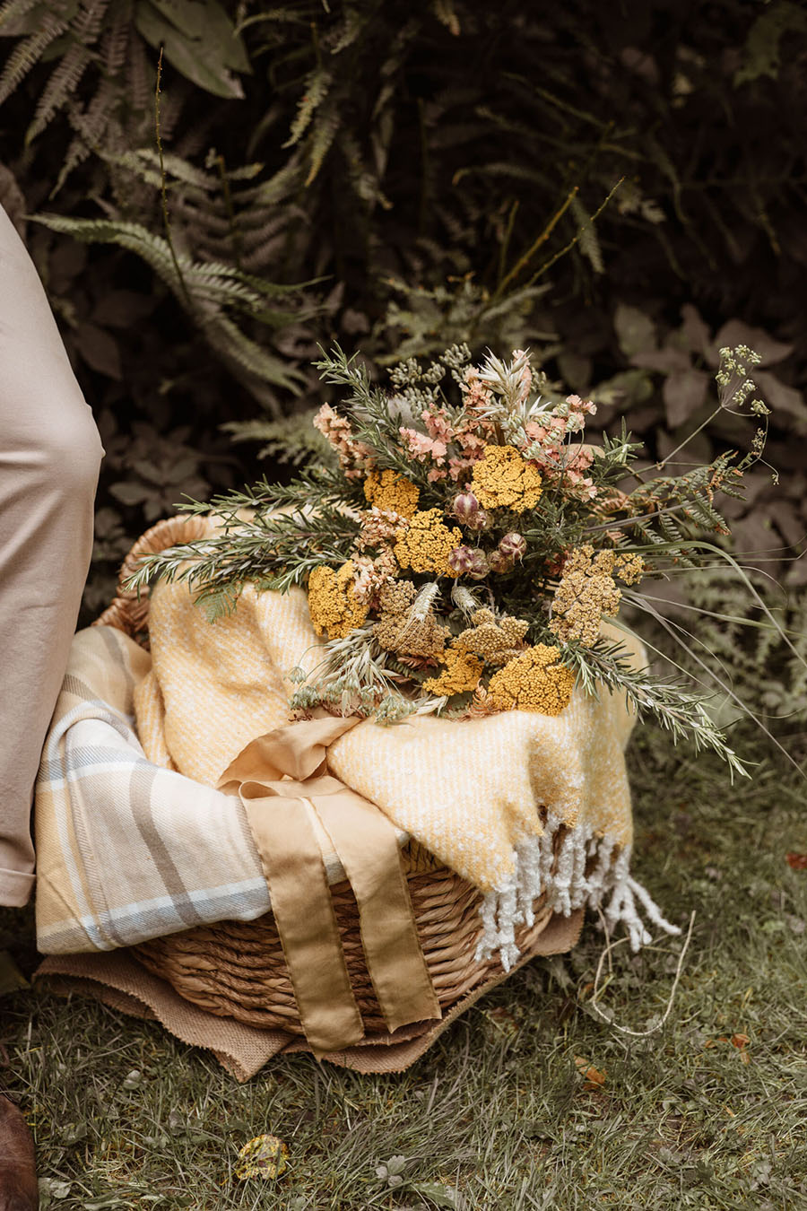 Yellow autumnal floral bouquet in a basket full of cosy blankets. Photographer credit Sarah Hoyle, styling by Amethyst Weddings