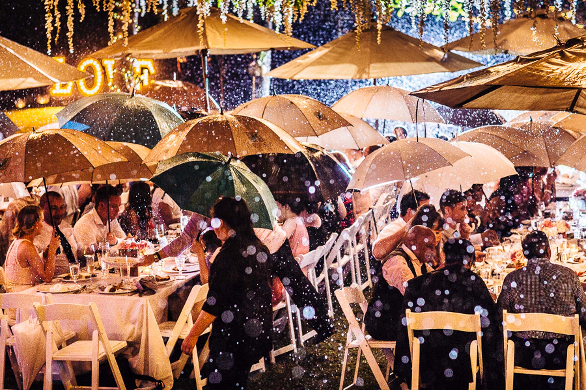 Umbrellas at an outdoor wedding reception by Liam Collard Photography