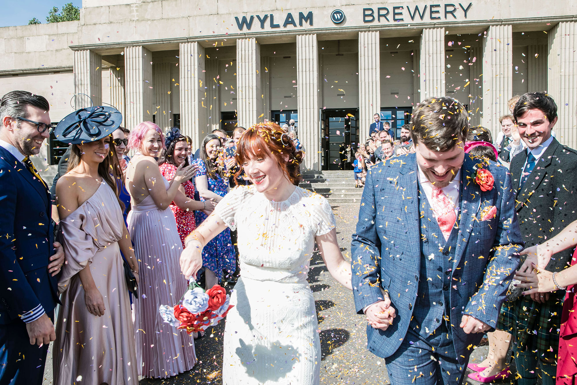 Bride and groom walking through confetti outside Wylam Brewery, by Erika Tanith Photography