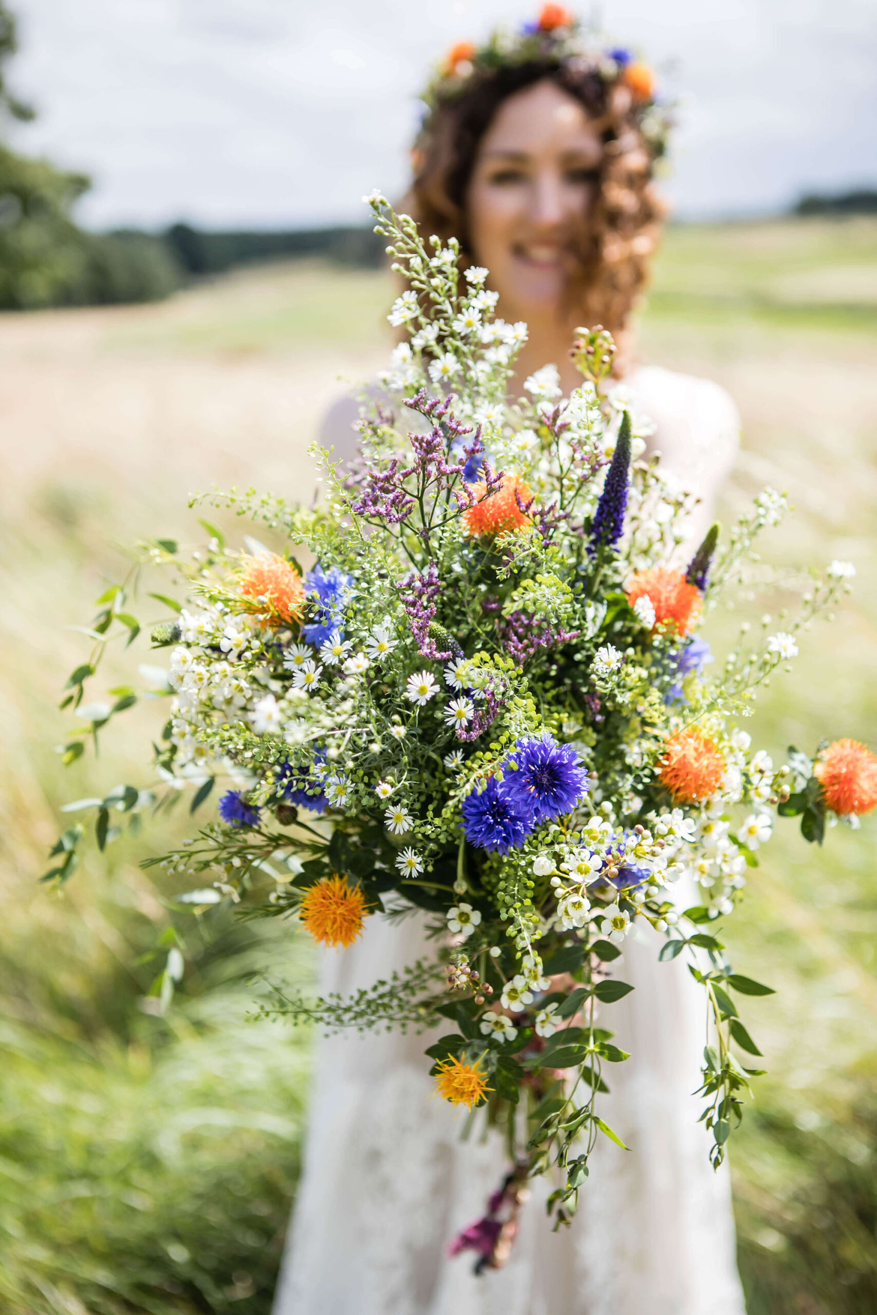 Gorgeous and colourful wildflower bouquet held by a bride, by Erika Tanith Photography