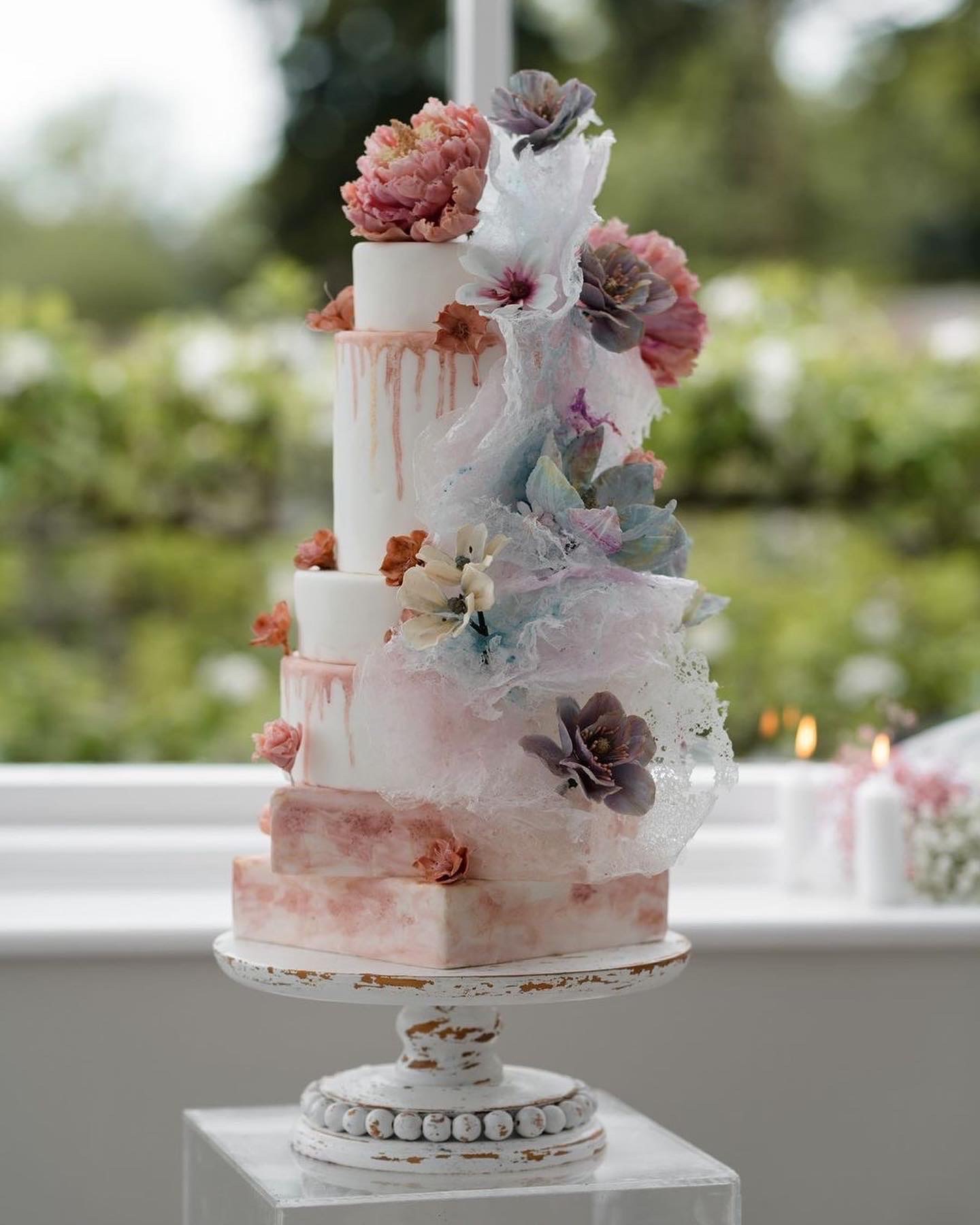 White and pink alternative layered wedding cake with botanical decoration. Botanical Cakes. Image by Adam Hudson Photography