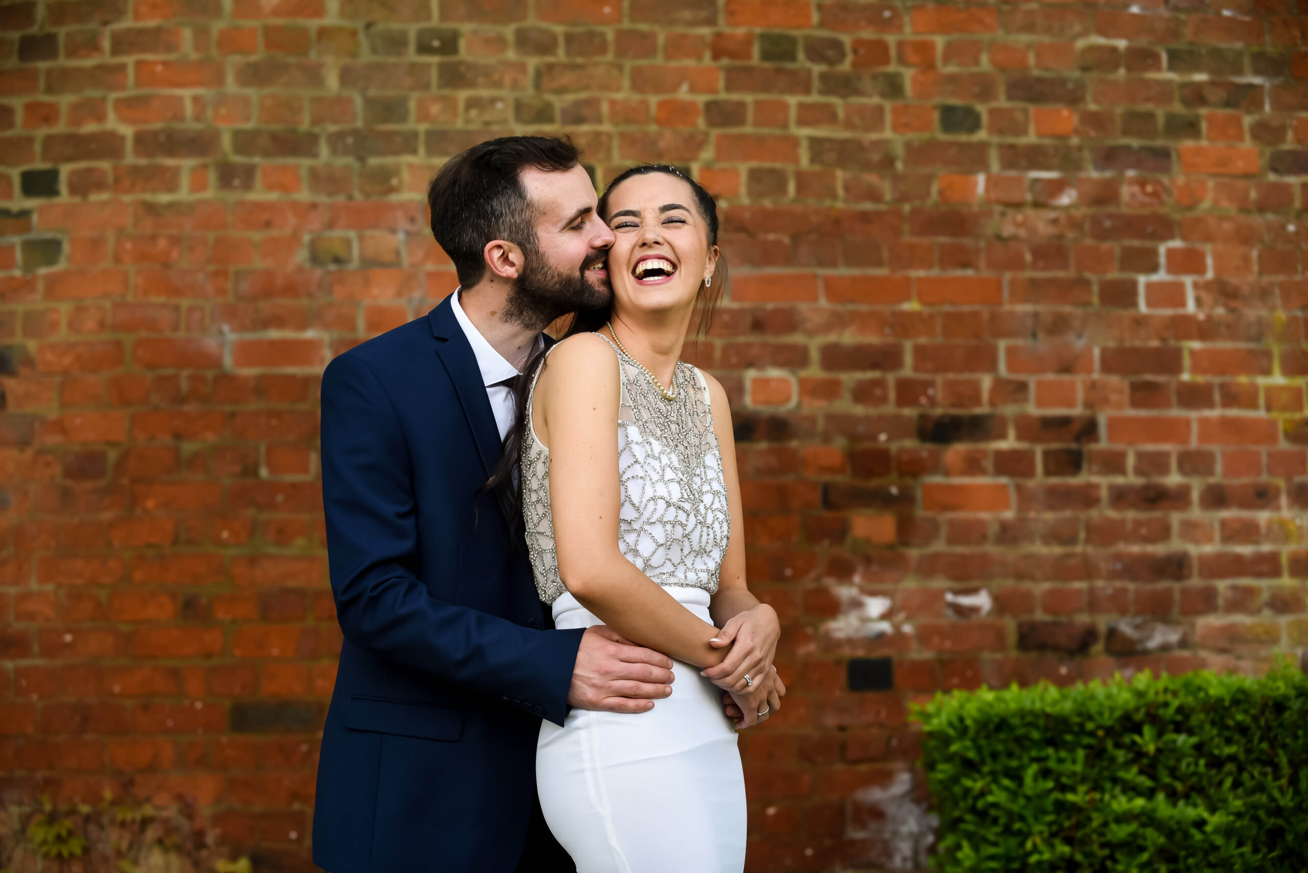 Newlyweds standing together and laughing, by Tori Deslauriers Photography