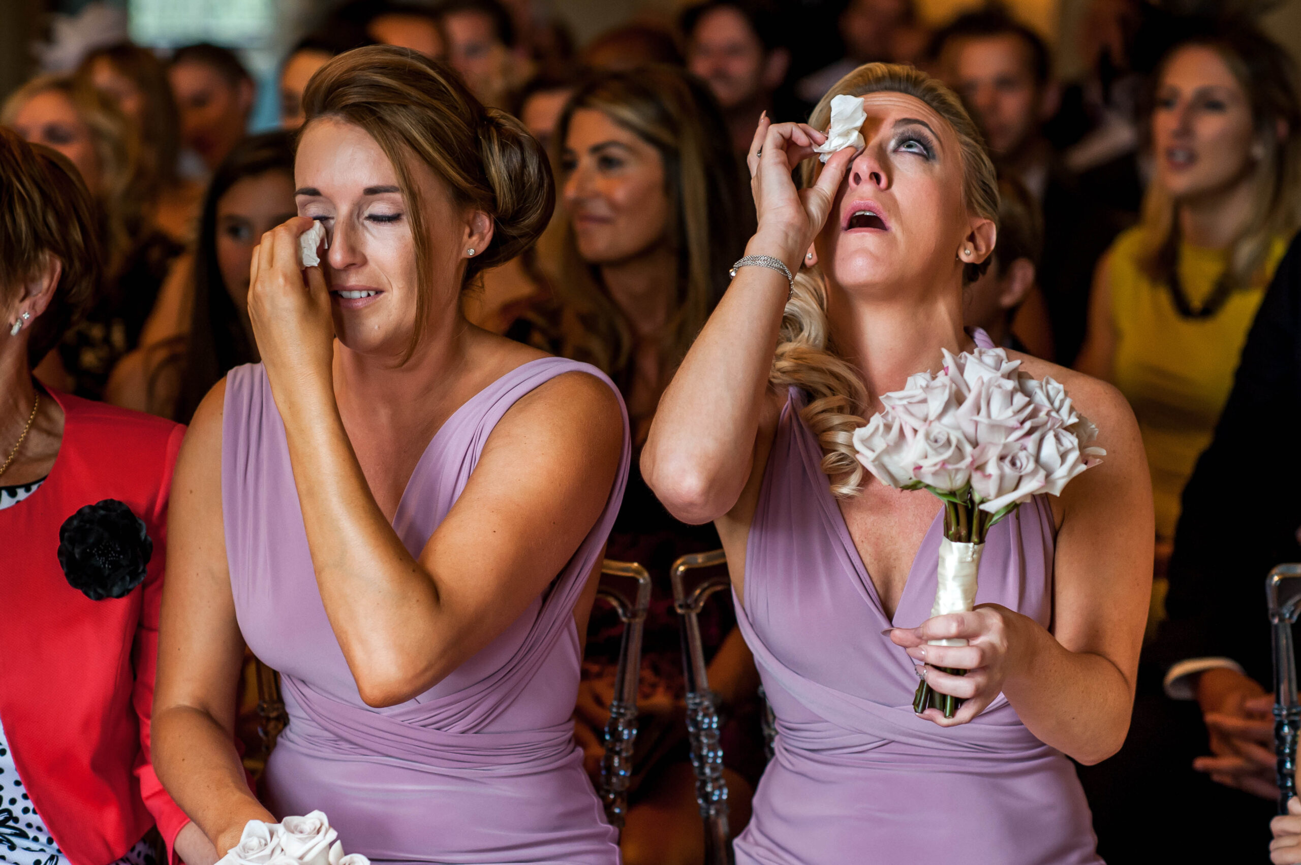 Bridesmaids wiping away tears during the ceremony, by Tori Deslauriers Photography