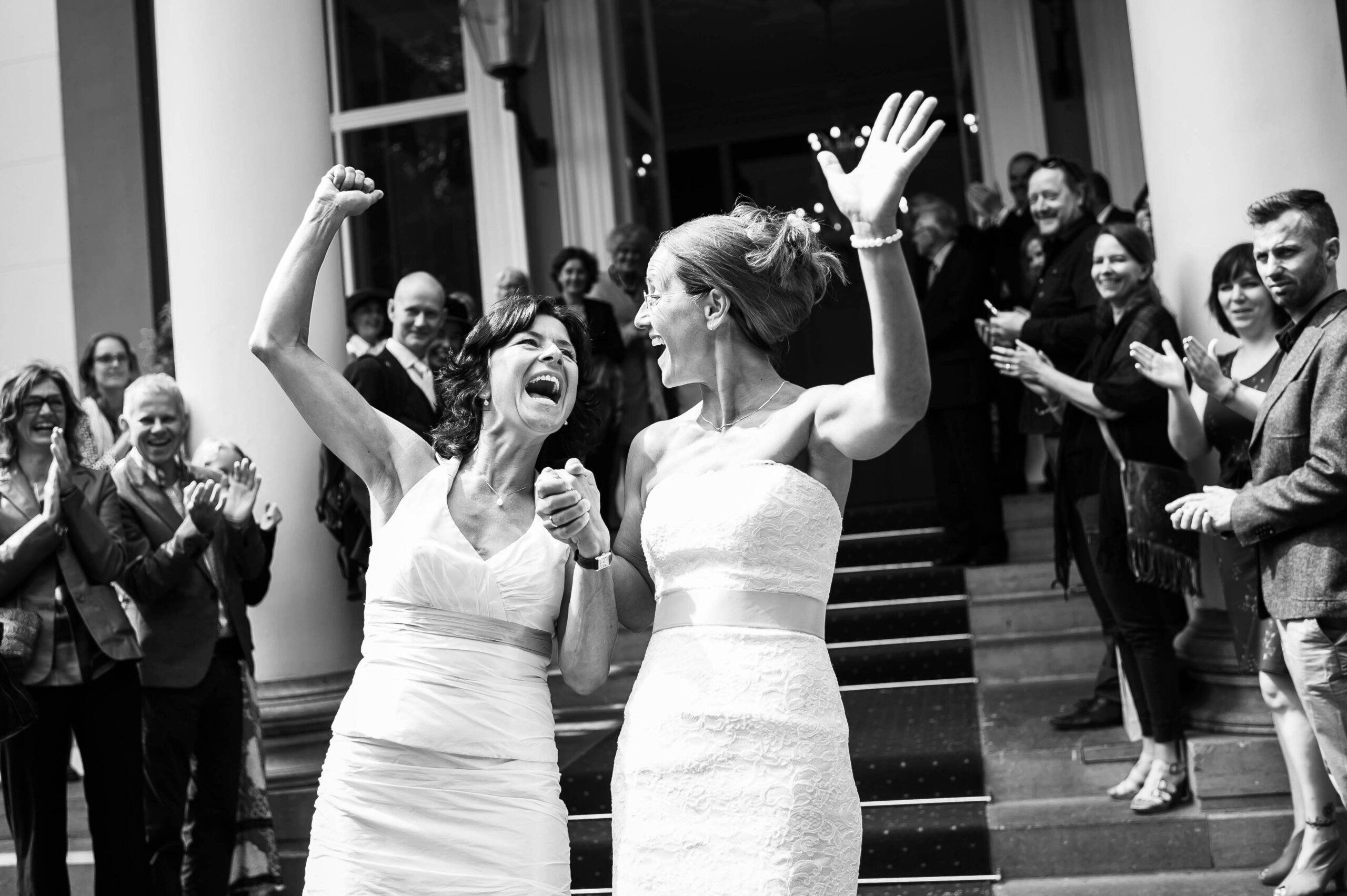 Newlyweds celebrating as they come out of the wedding venue, by Tori Deslauriers Photography