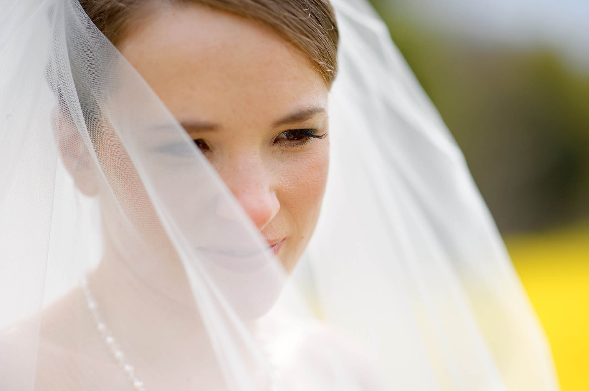 Close up of a bride with her veil partially covering her face - Sheffield wedding photographer John Mottershaw
