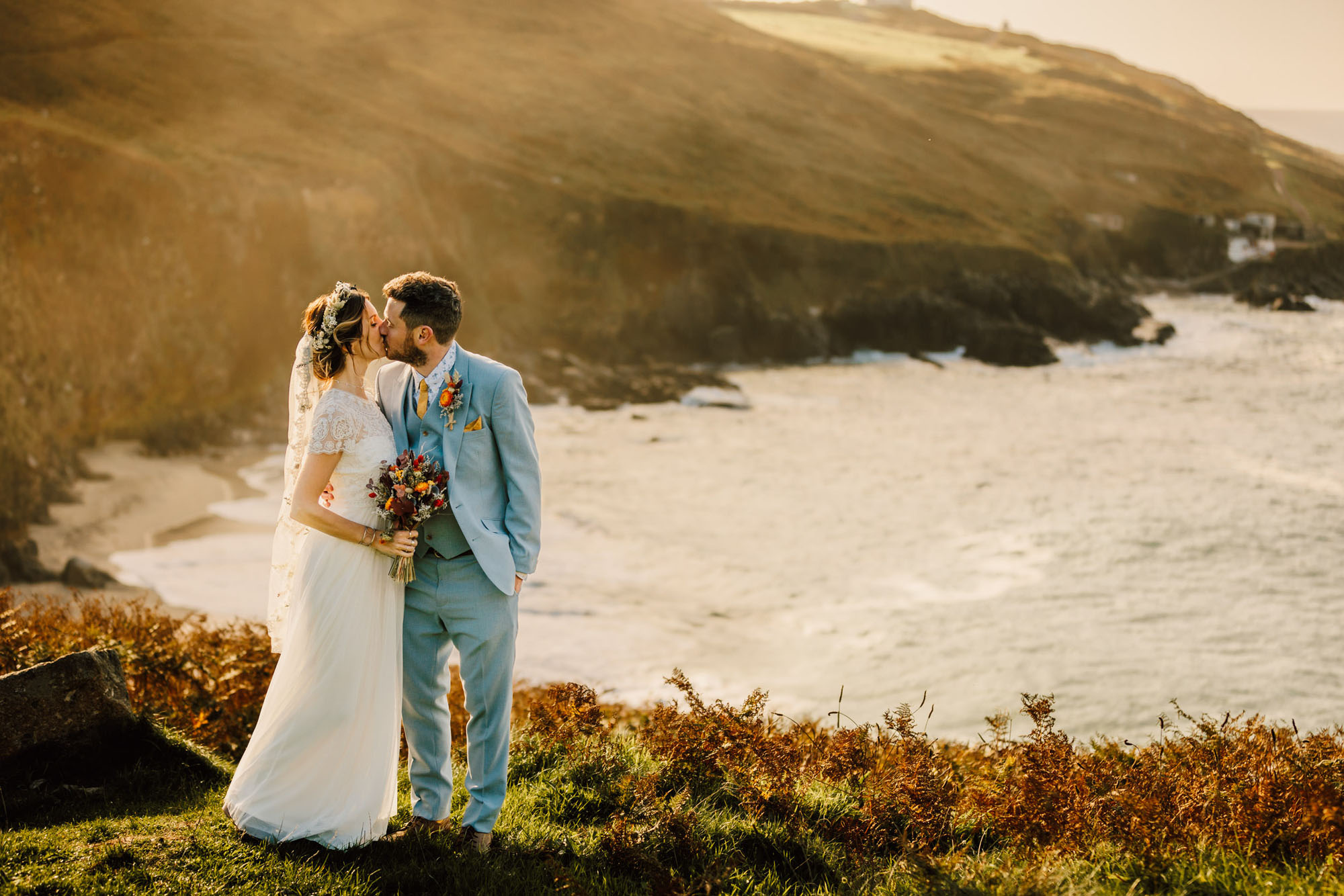 Beautiful golden wedding photo on a Cornwall clifftop. By Chris Armstrong Photography in Cornwall