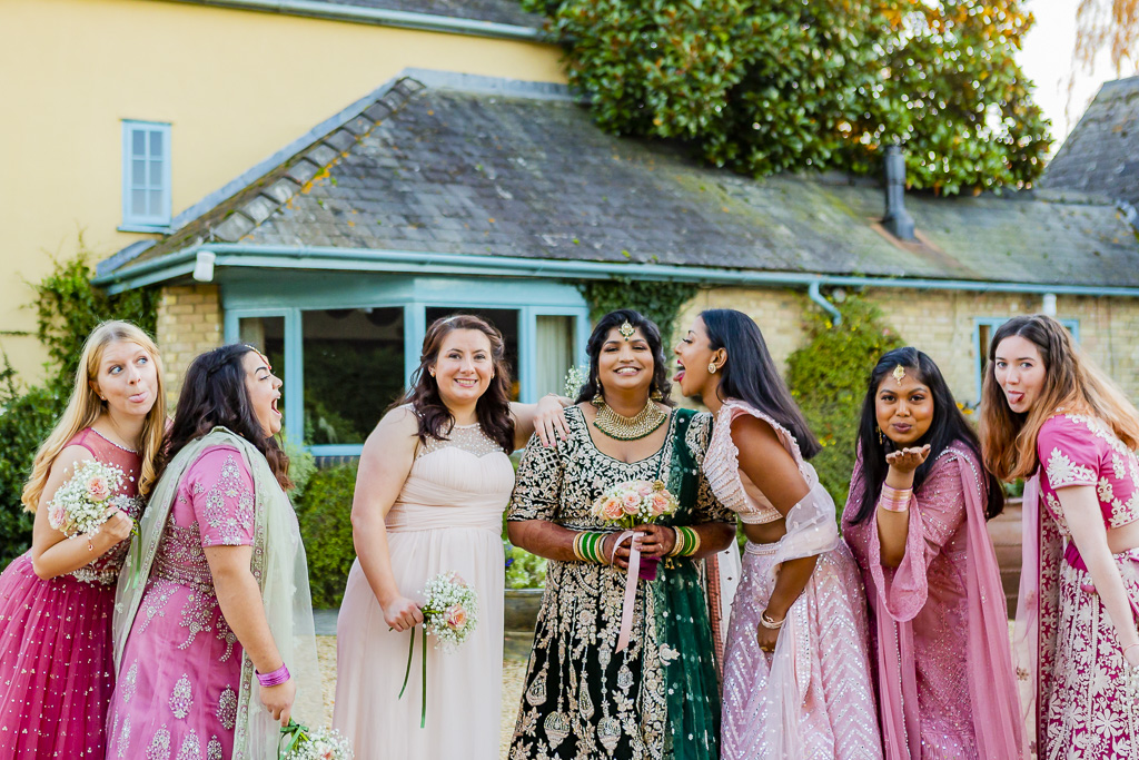 Fun and colourful wedding photo from an Indian wedding, with bridesmaids making cheeky faces to the camera and still looking amazing! by Ross Willsher Photography