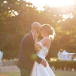 Golden hour wedding photo of a bride and groom holding each other close. By Snapdragon Photography in Devon