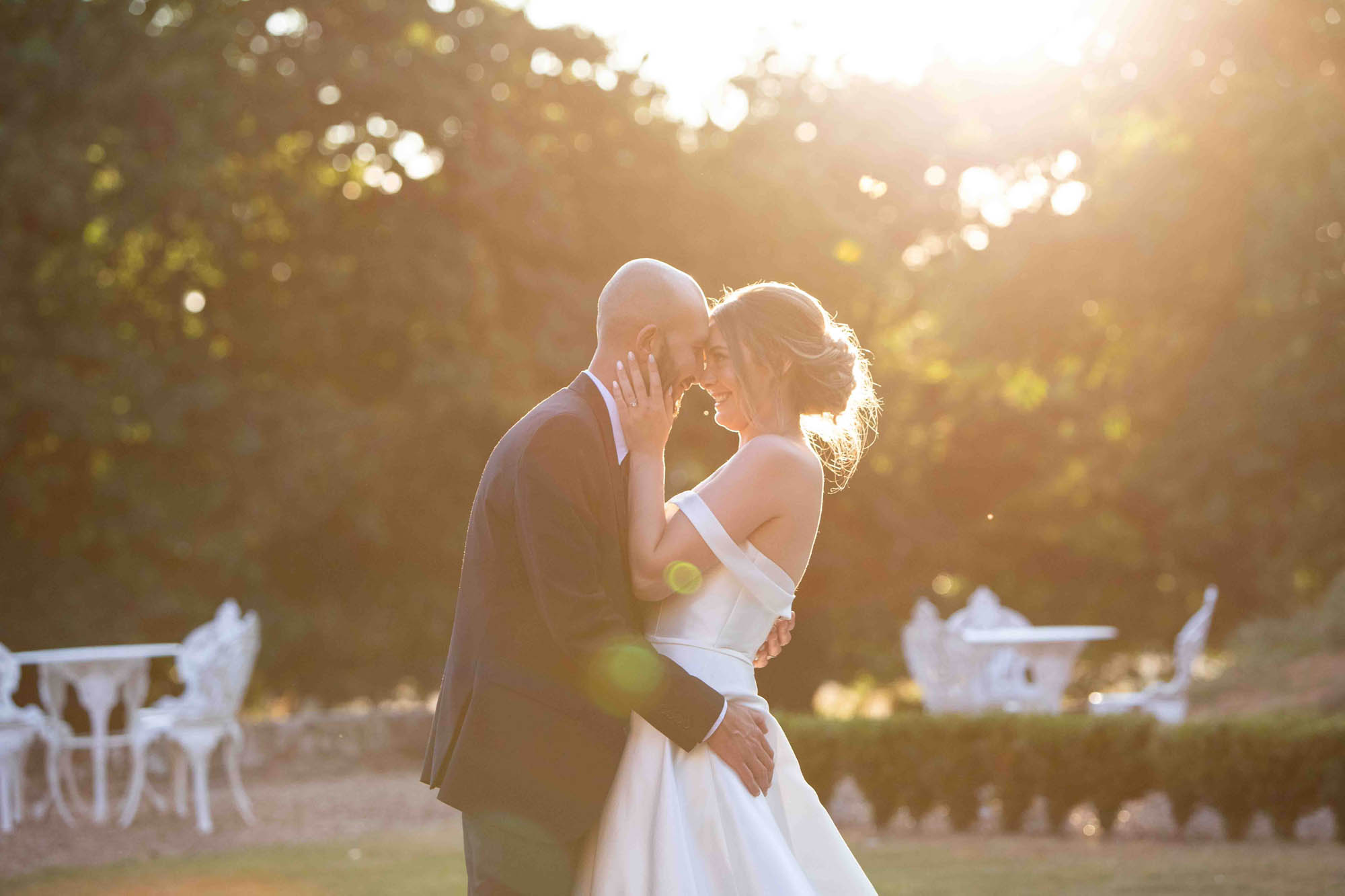 Golden hour wedding photo of a bride and groom holding each other close. By Snapdragon Photography in Devon