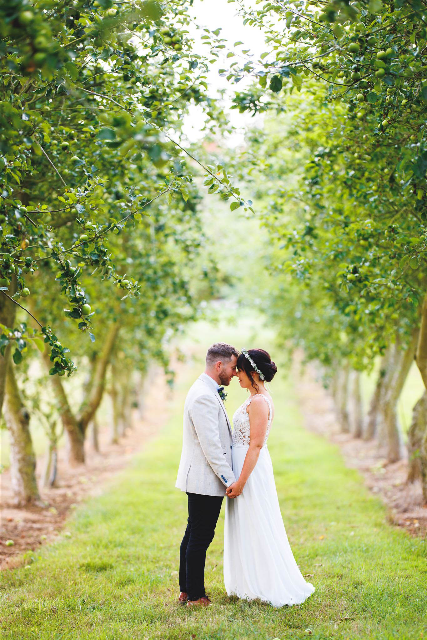 Newlyweds in a tree lined alleyway at The Orchard at Munsley