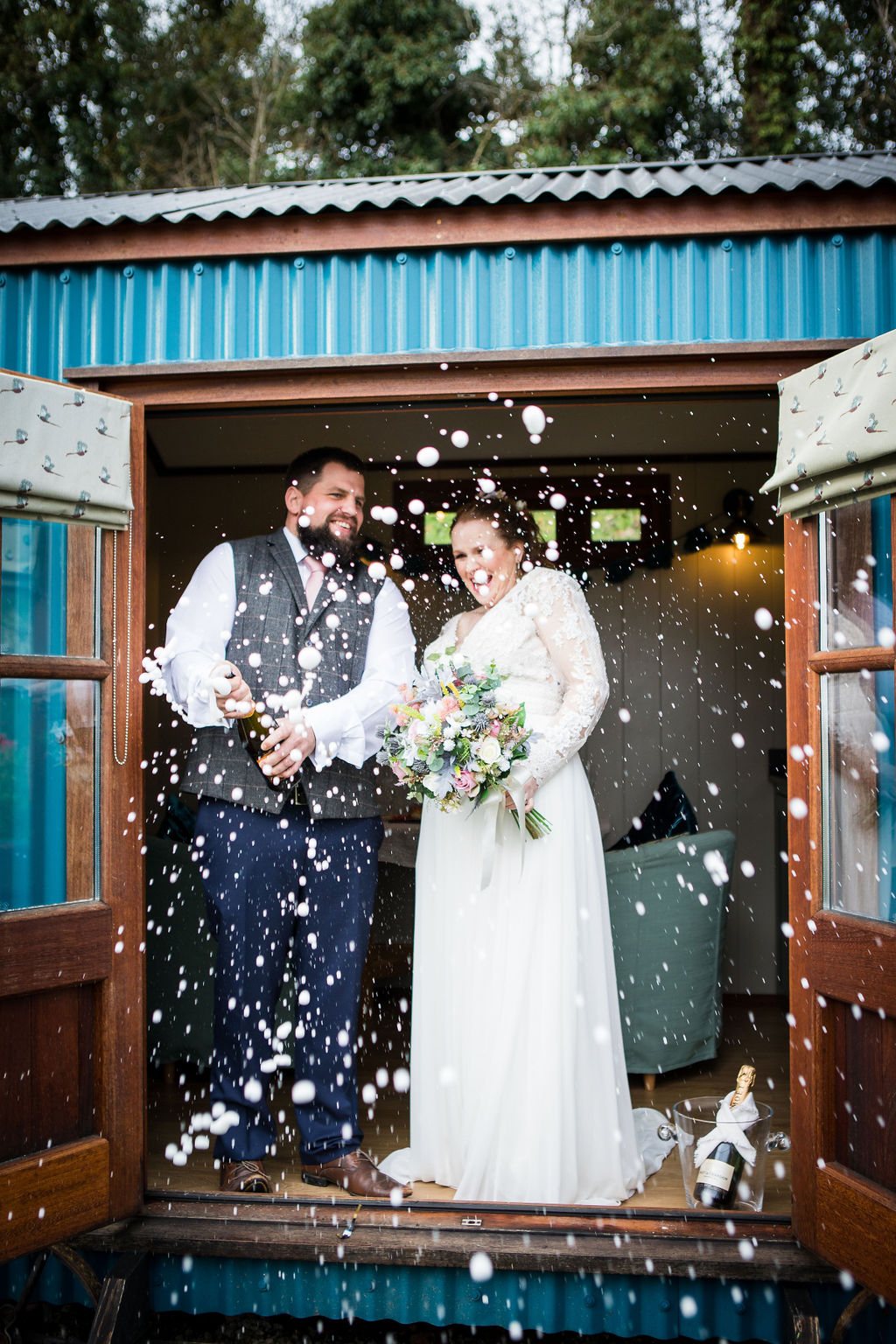 A bride and groom celebrating their wedding with a shower of confetti