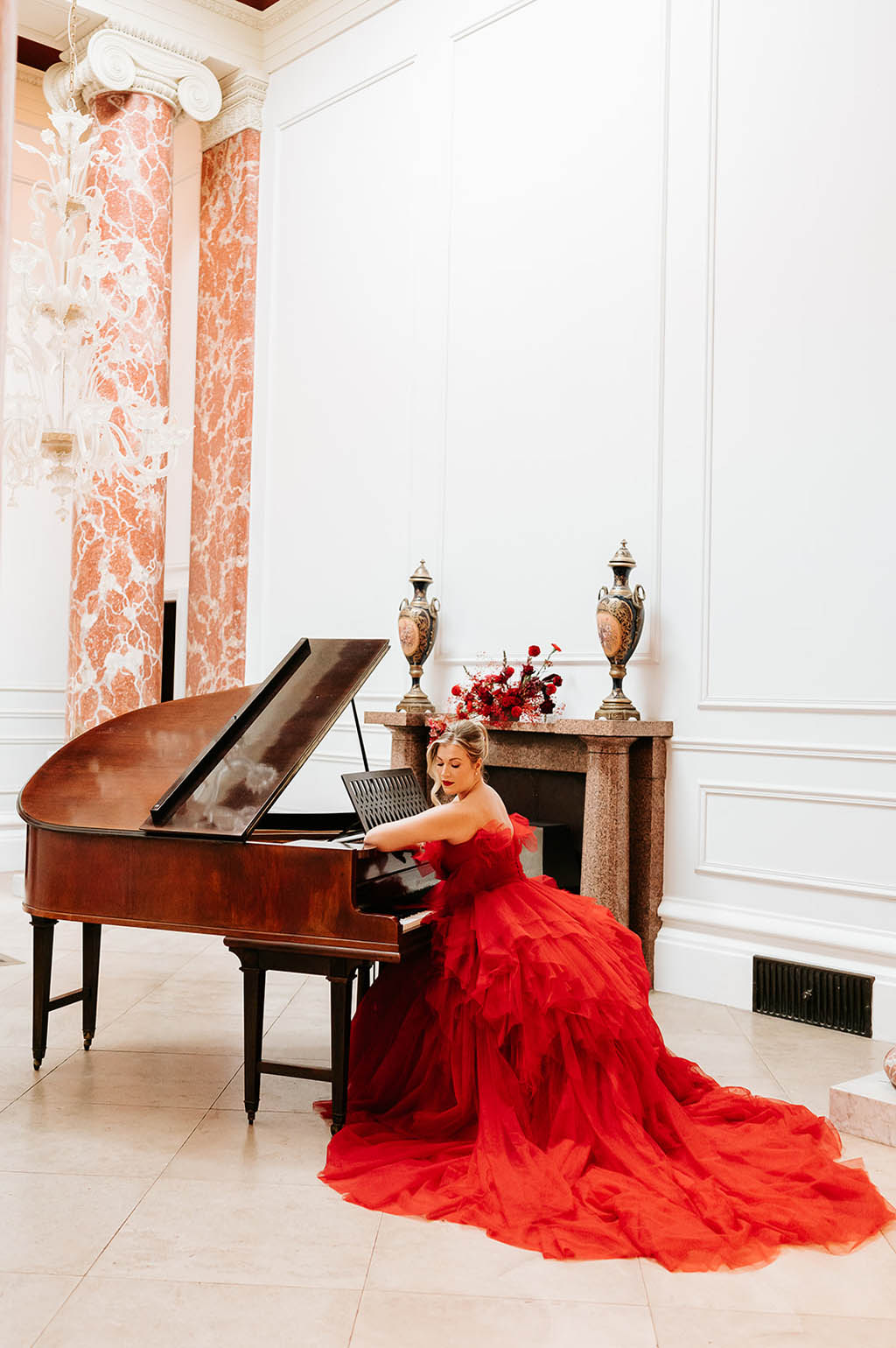 Model in red ballgown at a grand piano photographed at Fillongley Hall