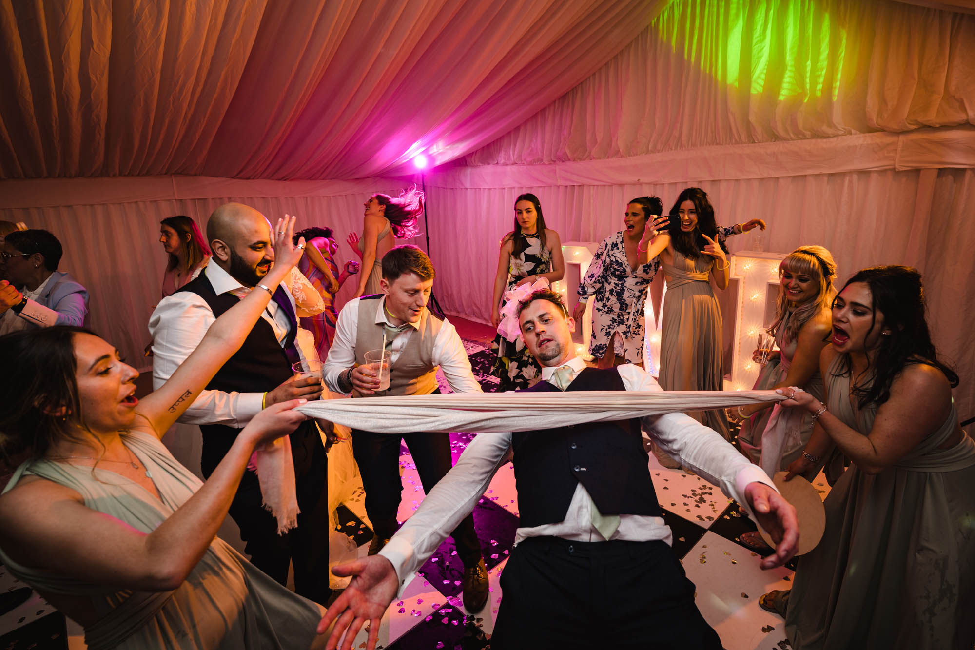 Wedding dancefloor photo with a guy doing limbo
