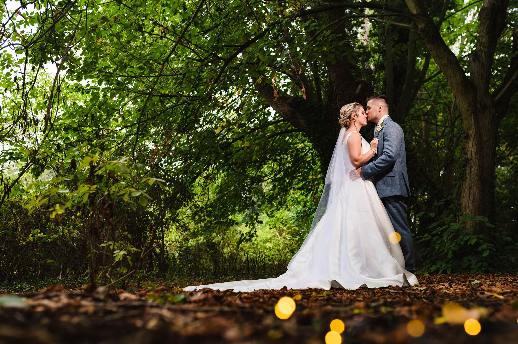 Newlyweds holding each other on a woodland path