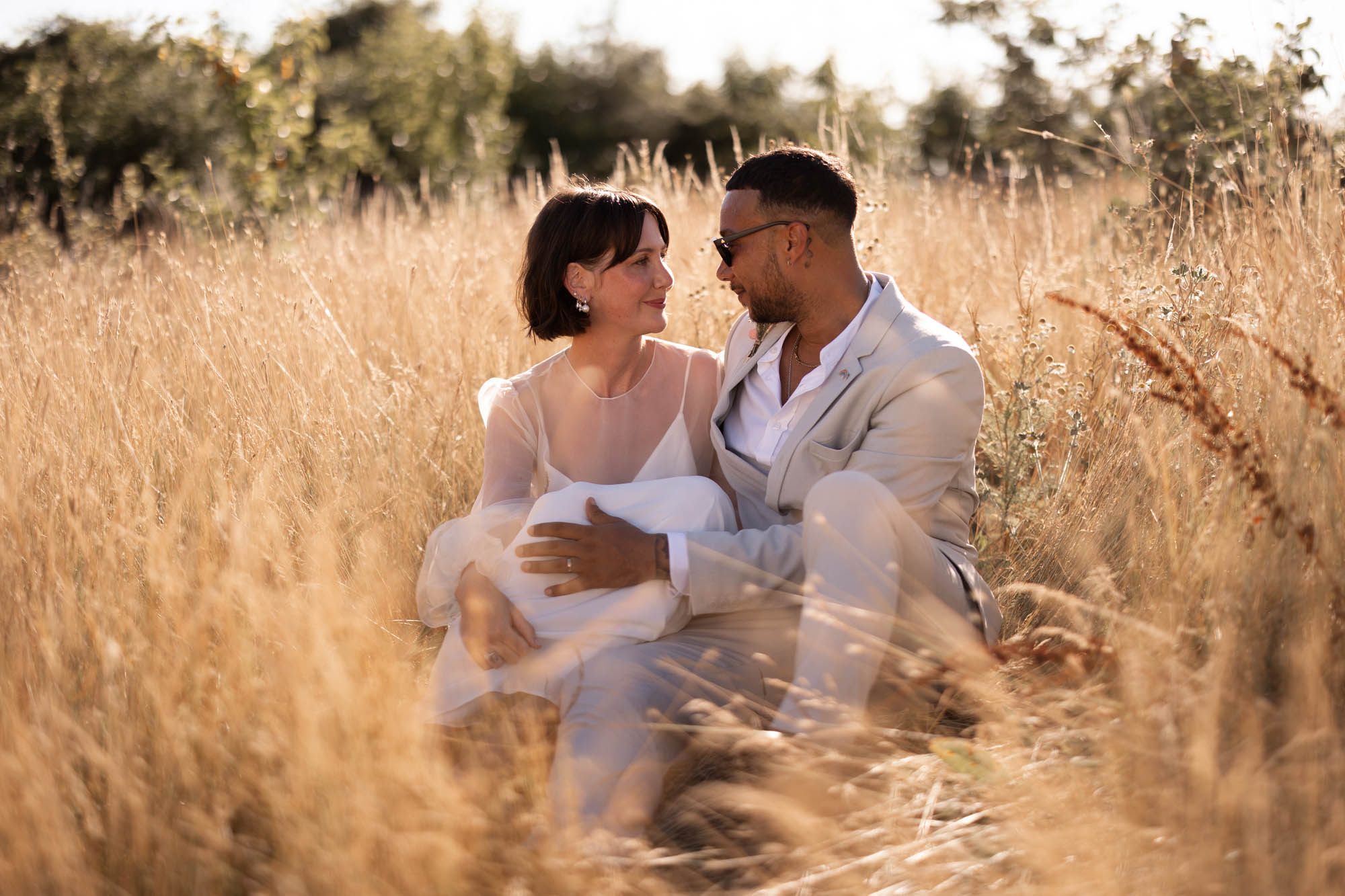 Couple in a hay meadow in the sunshine by Daniel Luke Photography