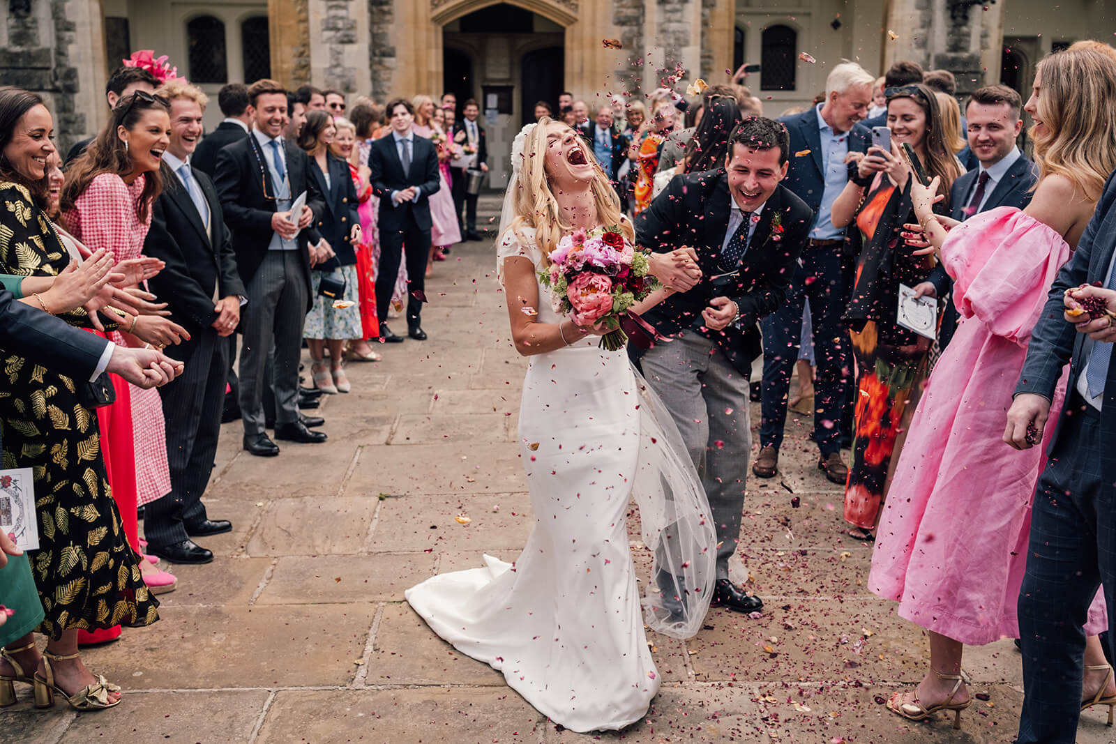 Bride laughing naturally during the confetti walk - with Emis Weddings in London