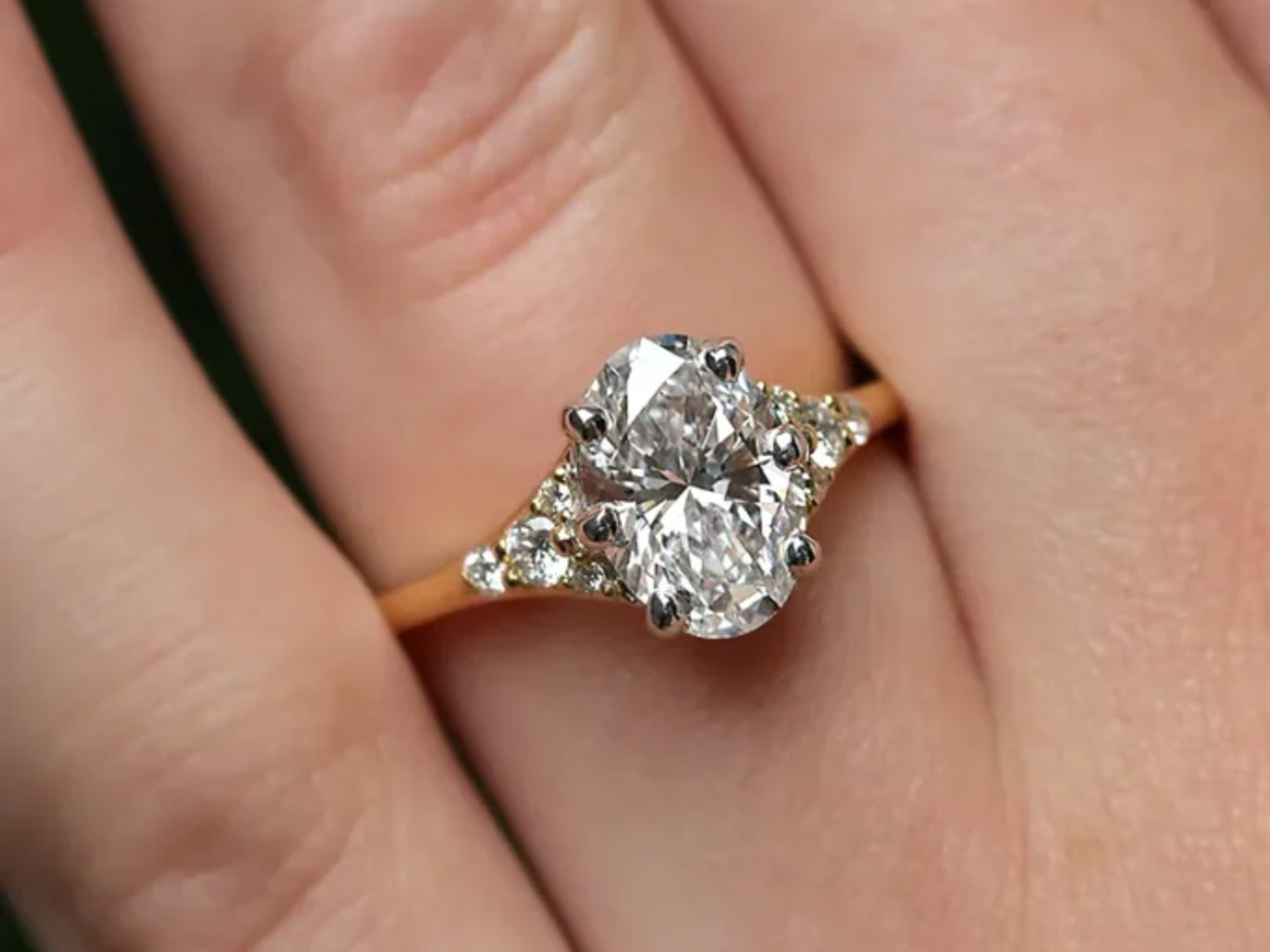 Sparkling oval diamond engagement ring worn by a model. By Bespoke Diamonds