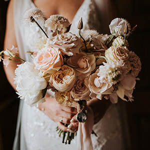 Bride holding a neutral, soft peach bouquet by Jemma Khan Studio
