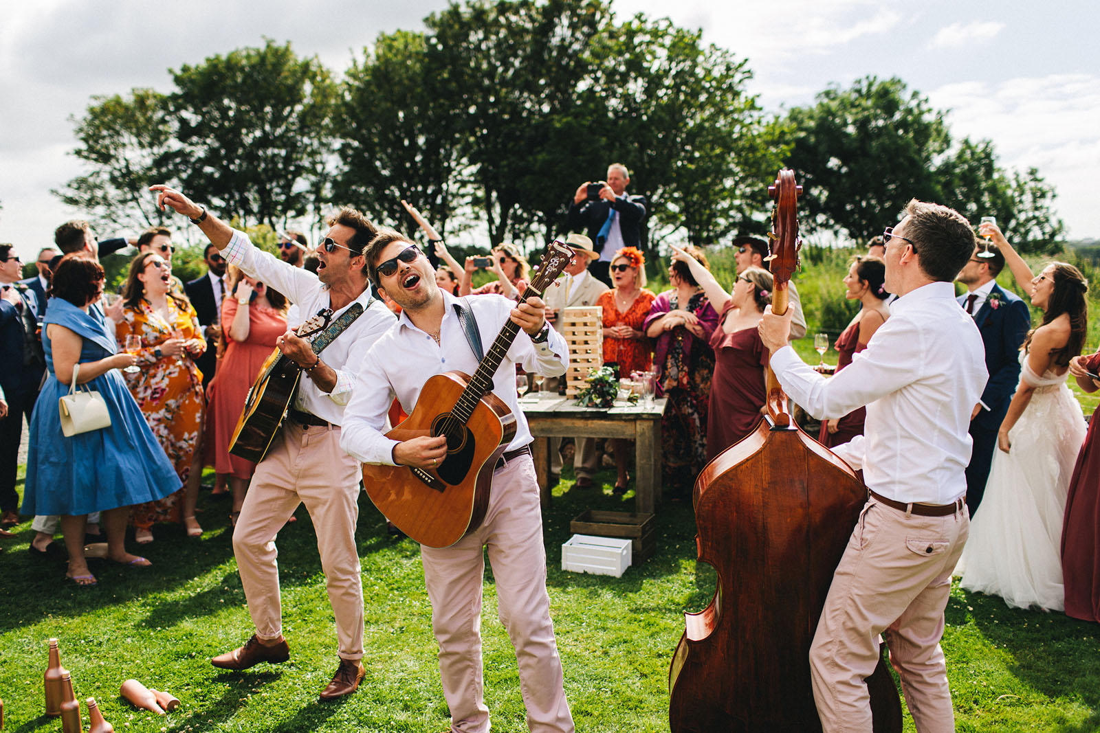 roaming wedding band with acoustic guitar and double bass outside at a wedding celebration
