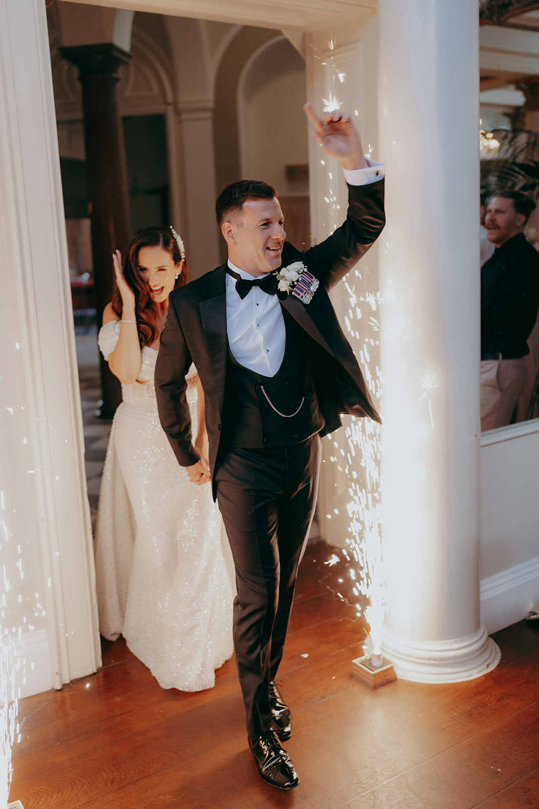 Groom and bride entering the evening reception with sparkler fountains to either side of them - image by Joss Denham Photography at Lartington Hall