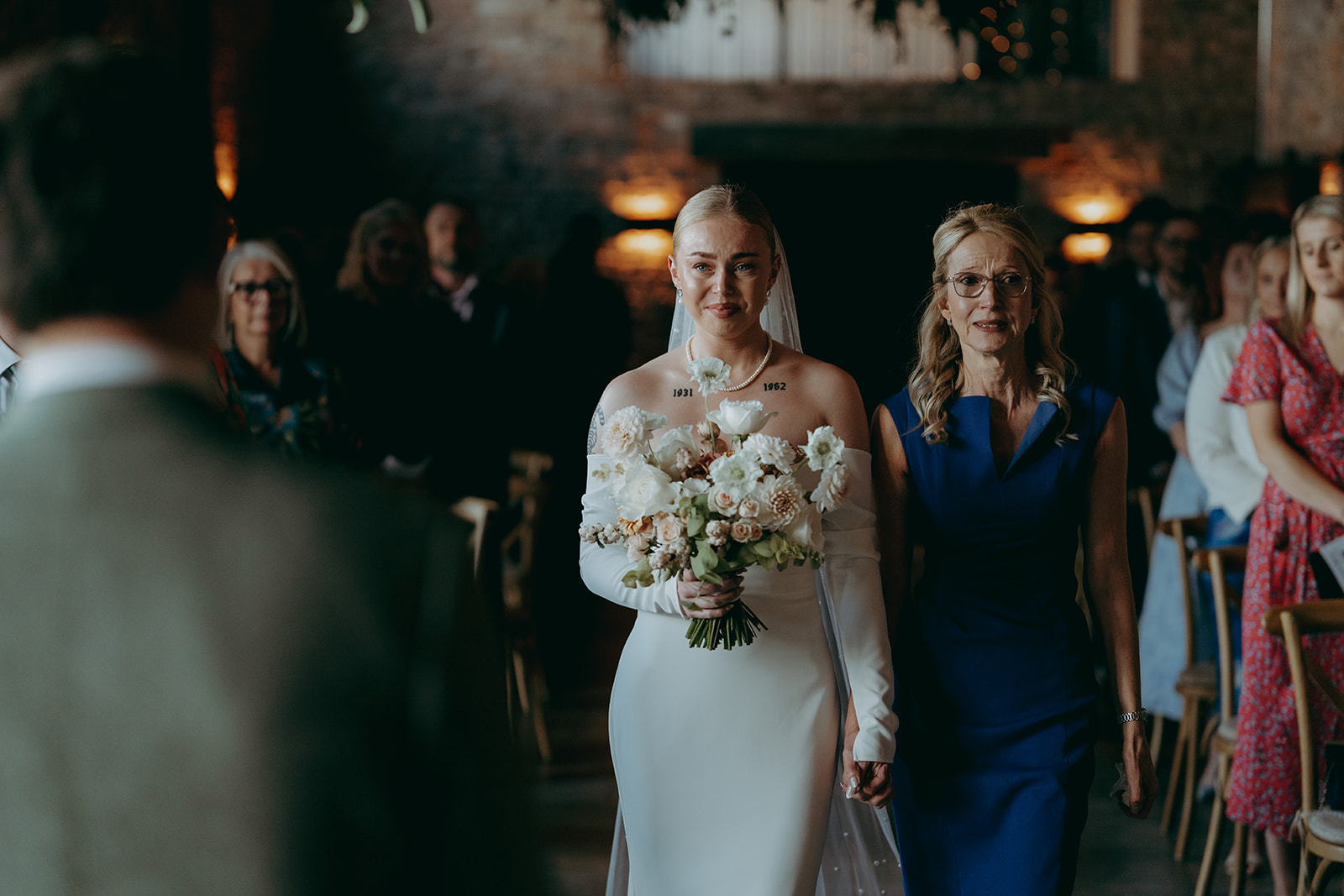 Real wedding at Thirsk Barn near Harrogate with a groom in a dark green suit and bride in a slim fitting dress with long gloves. Image by Yorkshire wedding photographer Joss Denham Photography