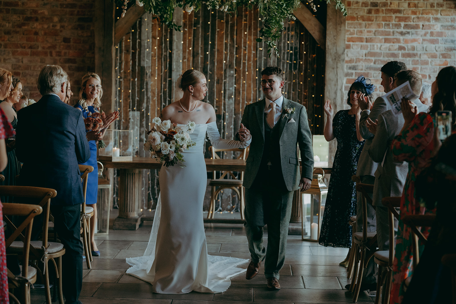 Real wedding at Thirsk Barn near Harrogate with a groom in a dark green suit and bride in a slim fitting dress with long gloves. Image by Yorkshire wedding photographer Joss Denham Photography