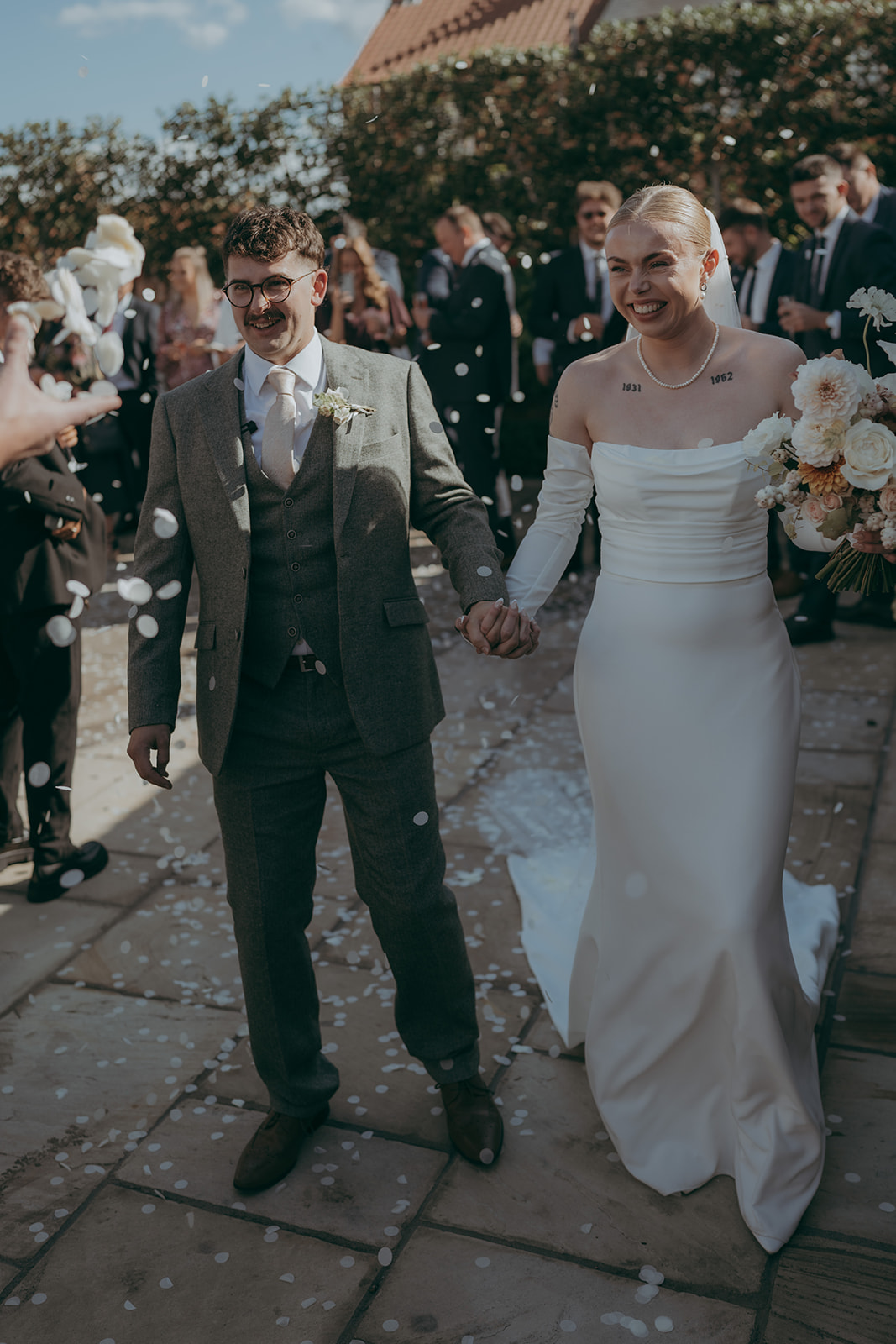Real wedding at Thirsk Barn near Harrogate with a groom in a dark green suit and bride in a slim fitting dress with long gloves. Image by Yorkshire wedding photographer Joss Denham Photography
