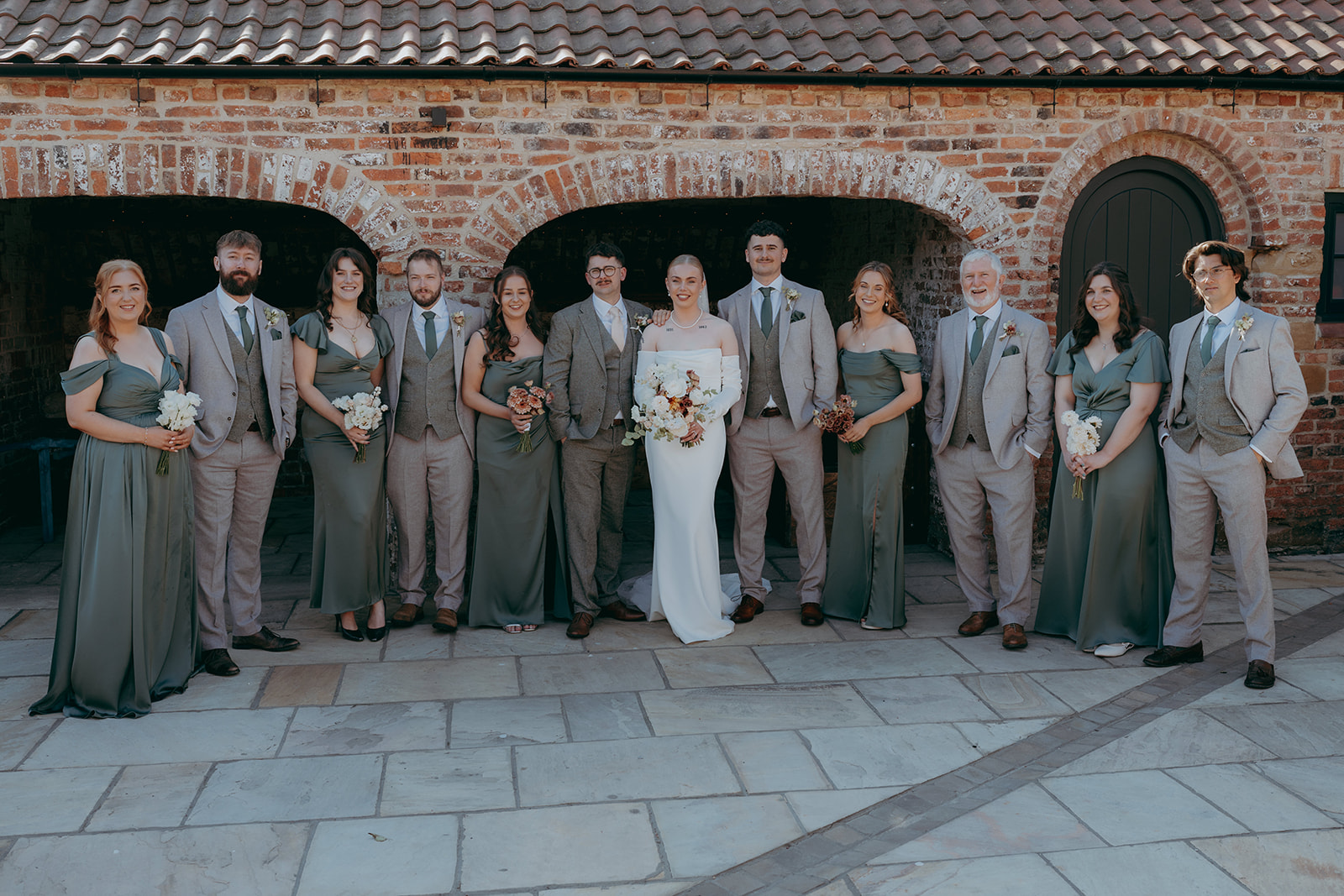 Real wedding at Thirsk Barn near Harrogate with a groom in a dark green suit and bride in a slim fitting dress with long gloves. Image by Yorkshire wedding photographer Joss Denham Photography