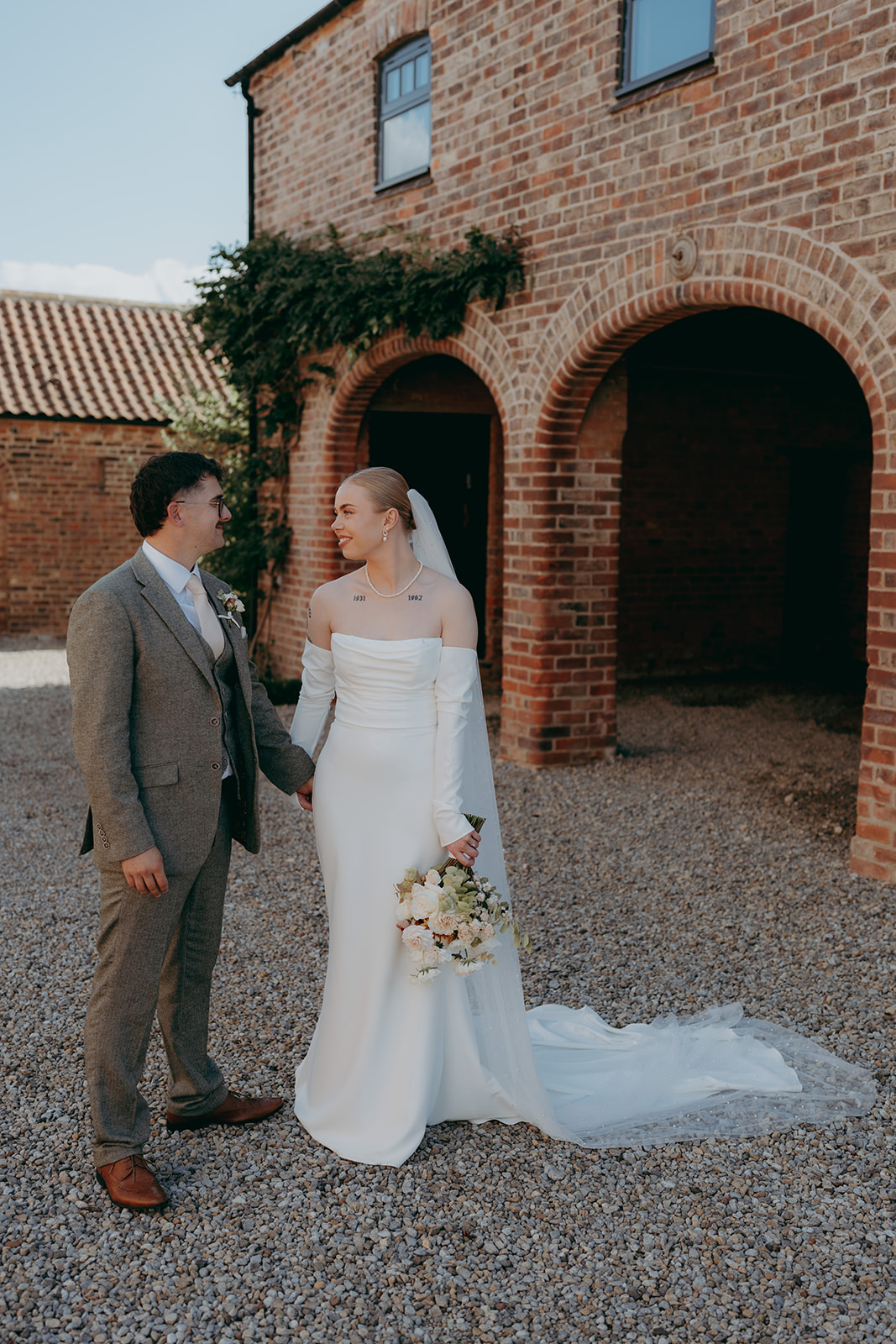 Real wedding at Thirsk Barn near Harrogate with a groom in a dark green suit and bride in a slim fitting dress with long gloves. Image by Yorkshire wedding photographer Joss Denham Photography