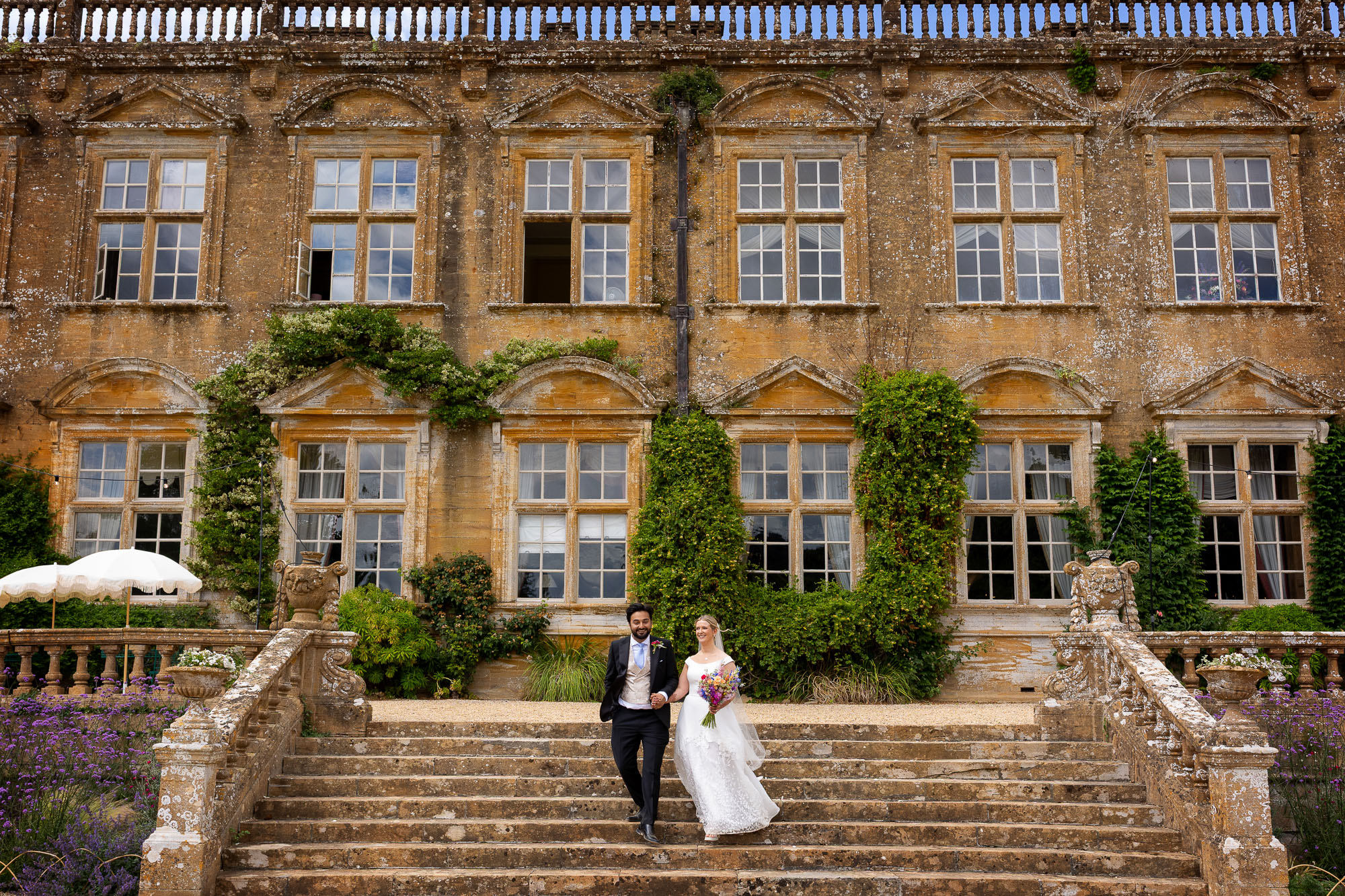 Photographs from an Indian wedding at Brympton House with really colourful flowers and a focus on human connection and love. By Martin Dabek Photography from Bristol