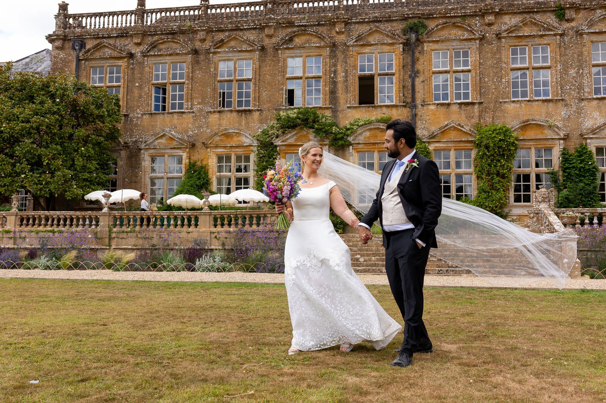 Photographs from an Indian wedding at Brympton House with really colourful flowers and a focus on human connection and love. By Martin Dabek Photography from Bristol
