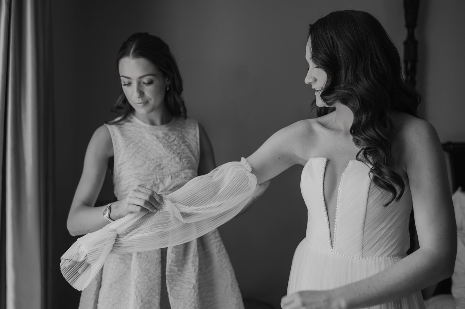 Beautiful editorial documentary style wedding photograph of a bride getting ready with her bridesmaid, by Damien Vickers in Cambridge